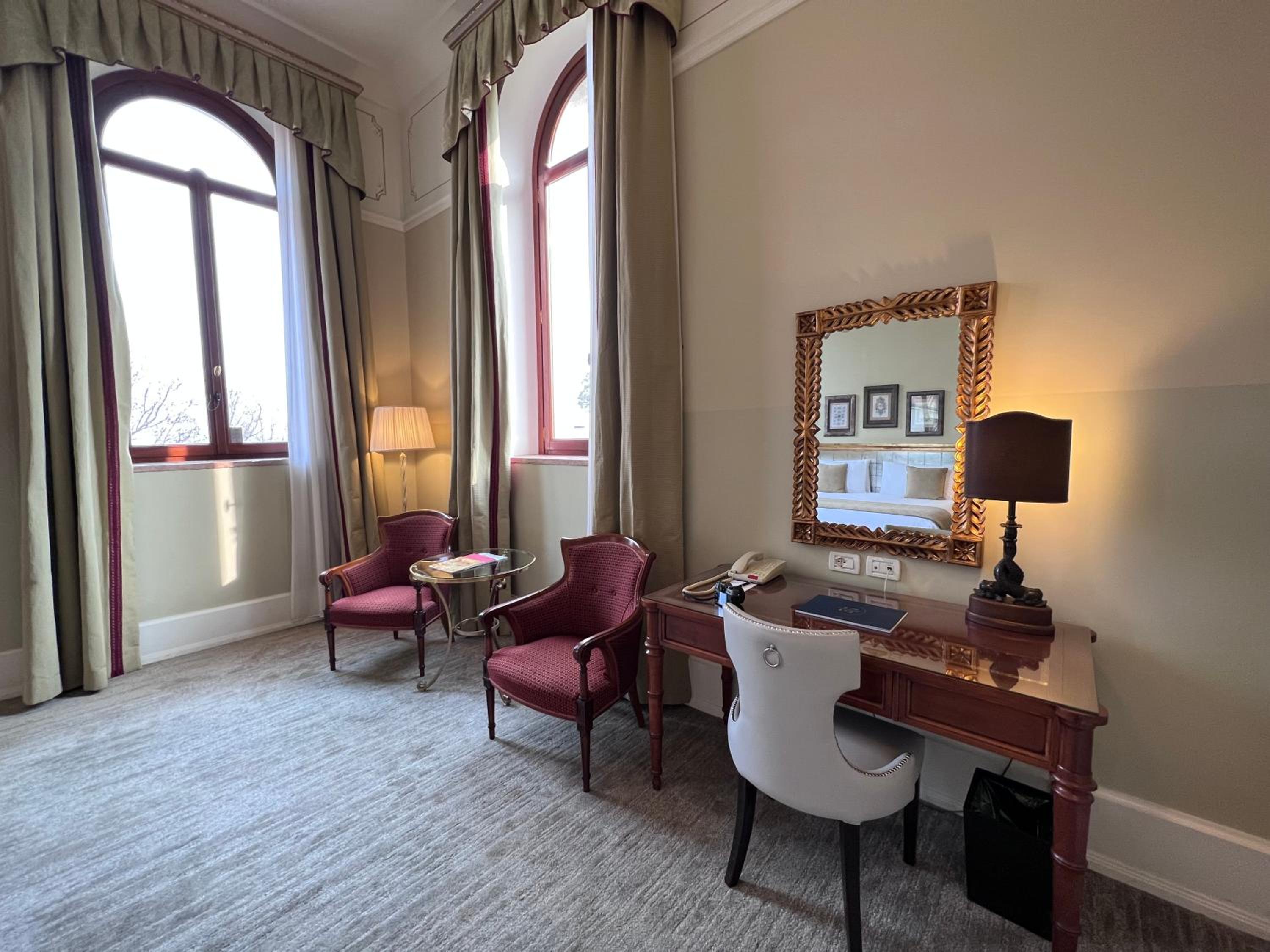 room with two chairs, a desk and a mirror