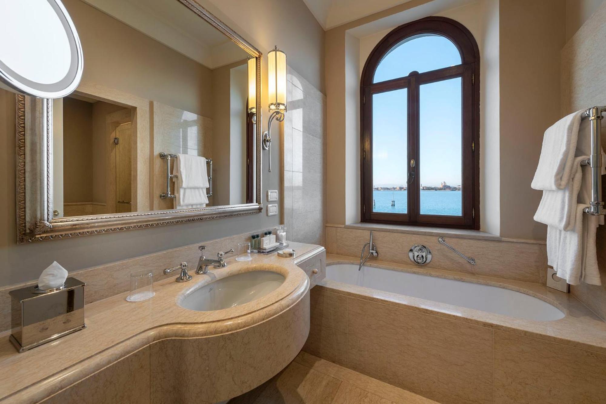 bathroom with a tub, sink, and large window