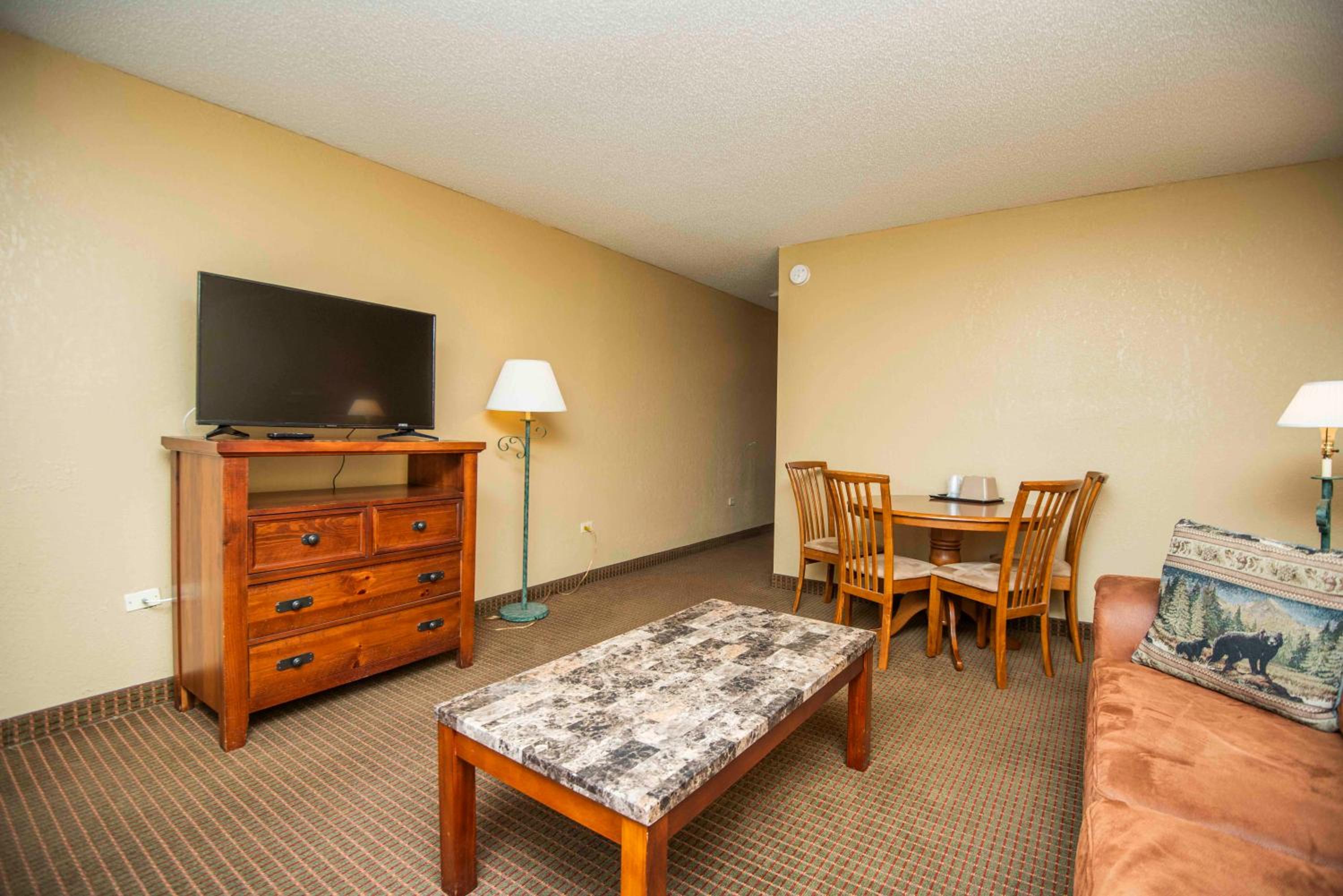 Hotel living area with sofa, dining table, and TV