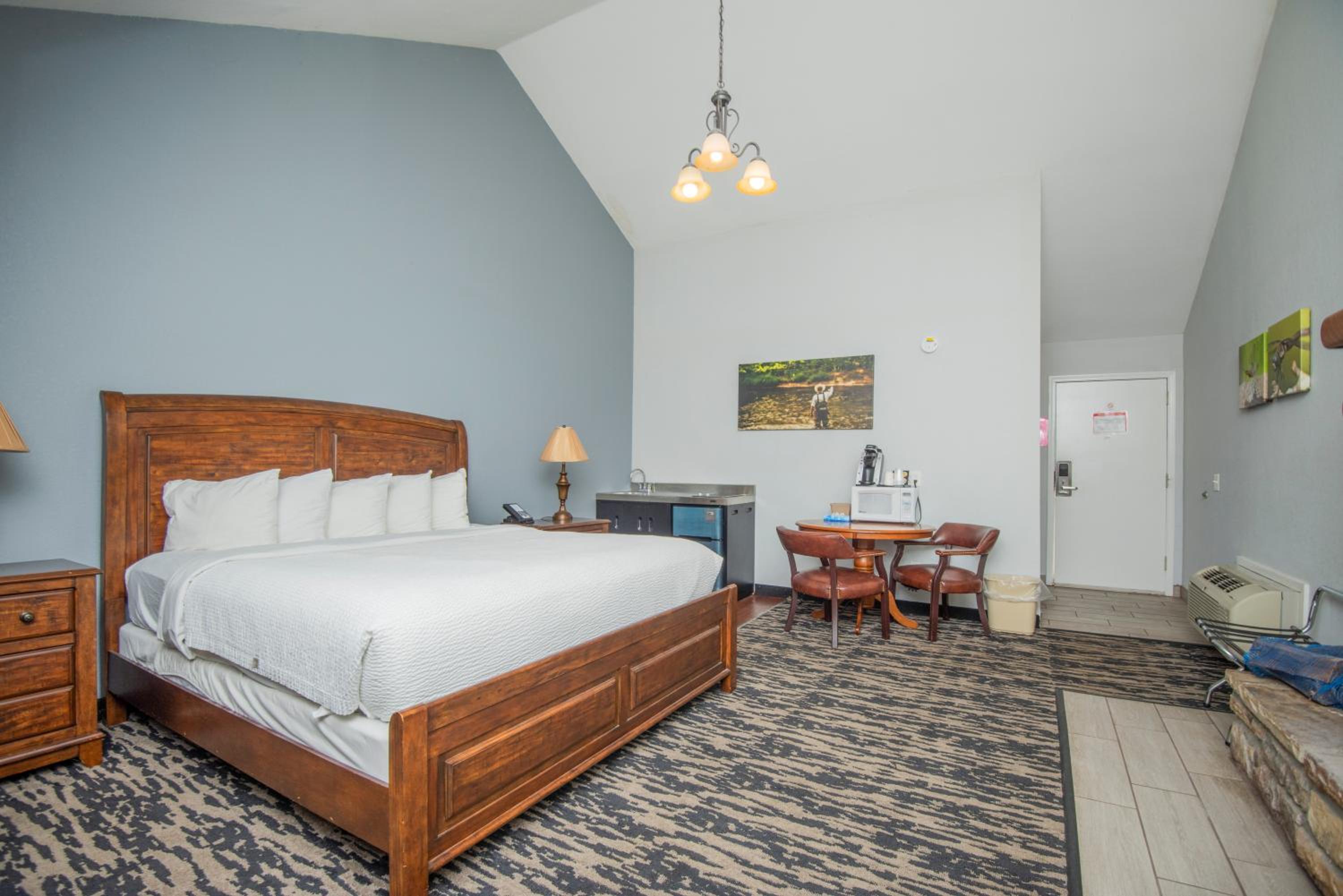 Hotel bedroom with wooden bed and kitchenette