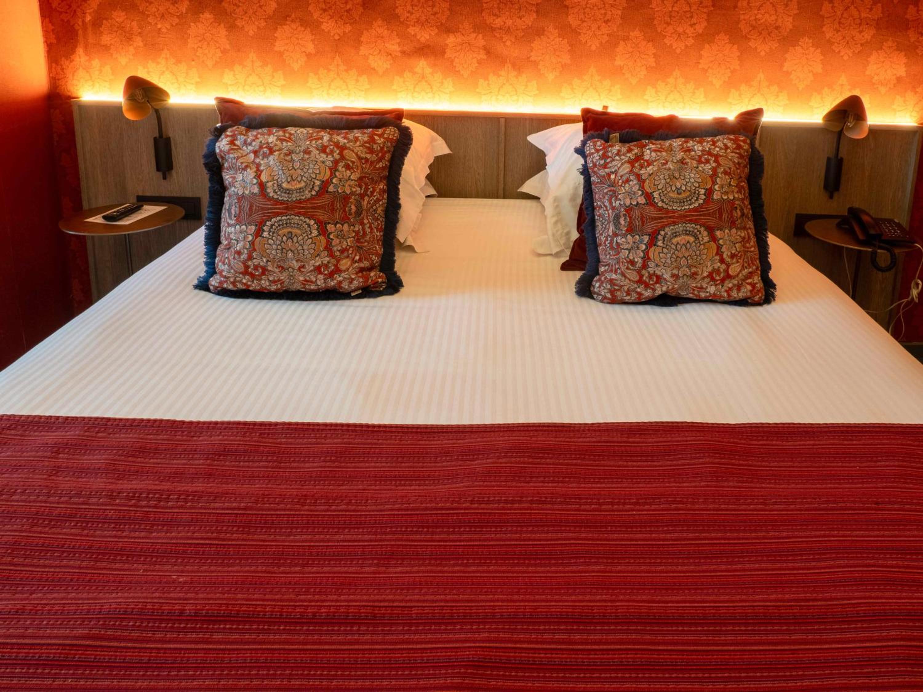 red and white bed with two pillows on top of it