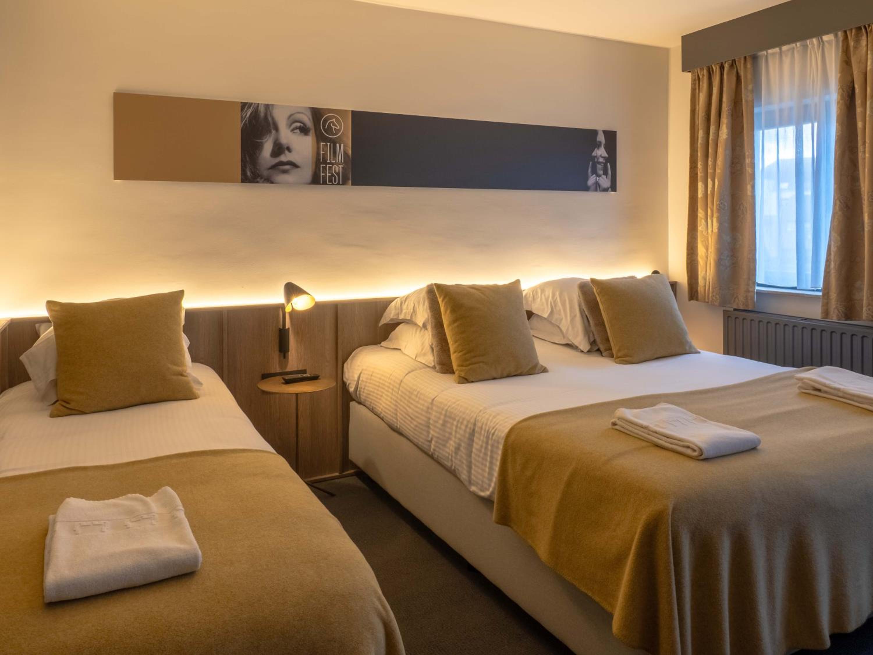 hotel room with two beds and towels on the bed