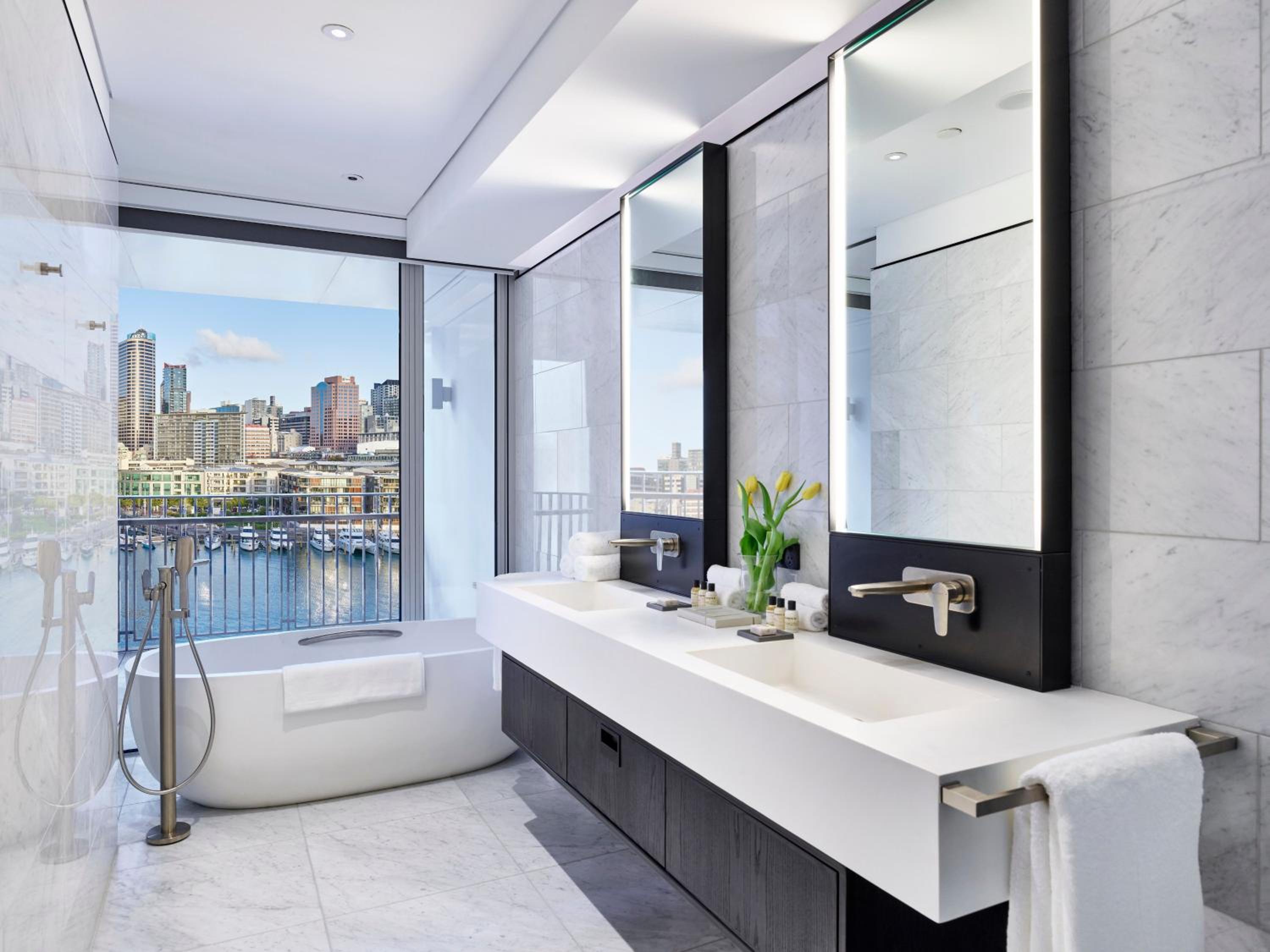 bathroom with a bathtub and a large window overlooking the city