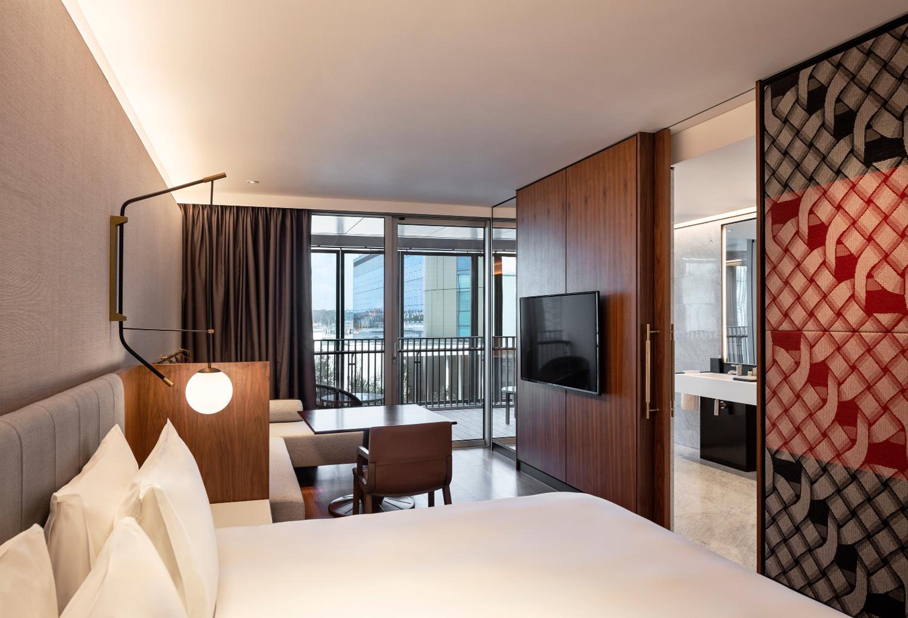 hotel room with a bed, desk, and television