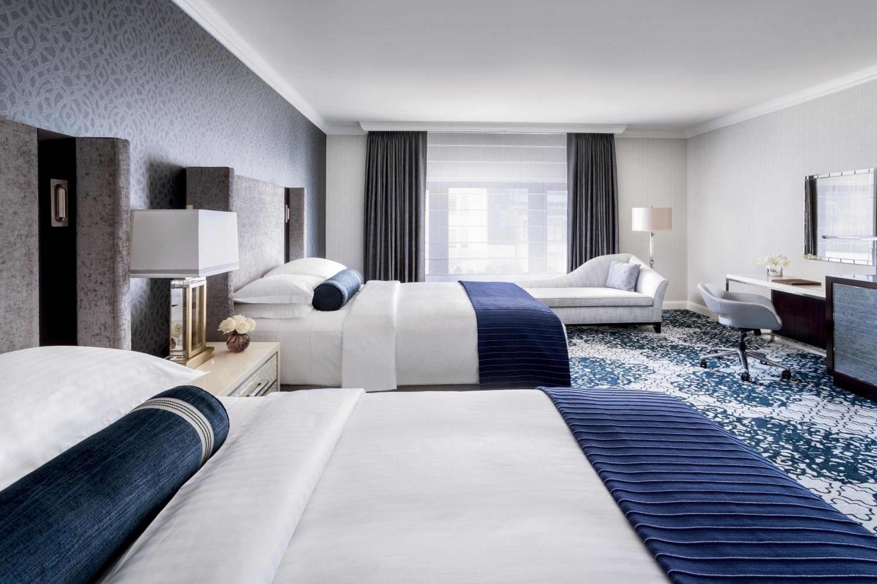 hotel room with two beds and a desk in it