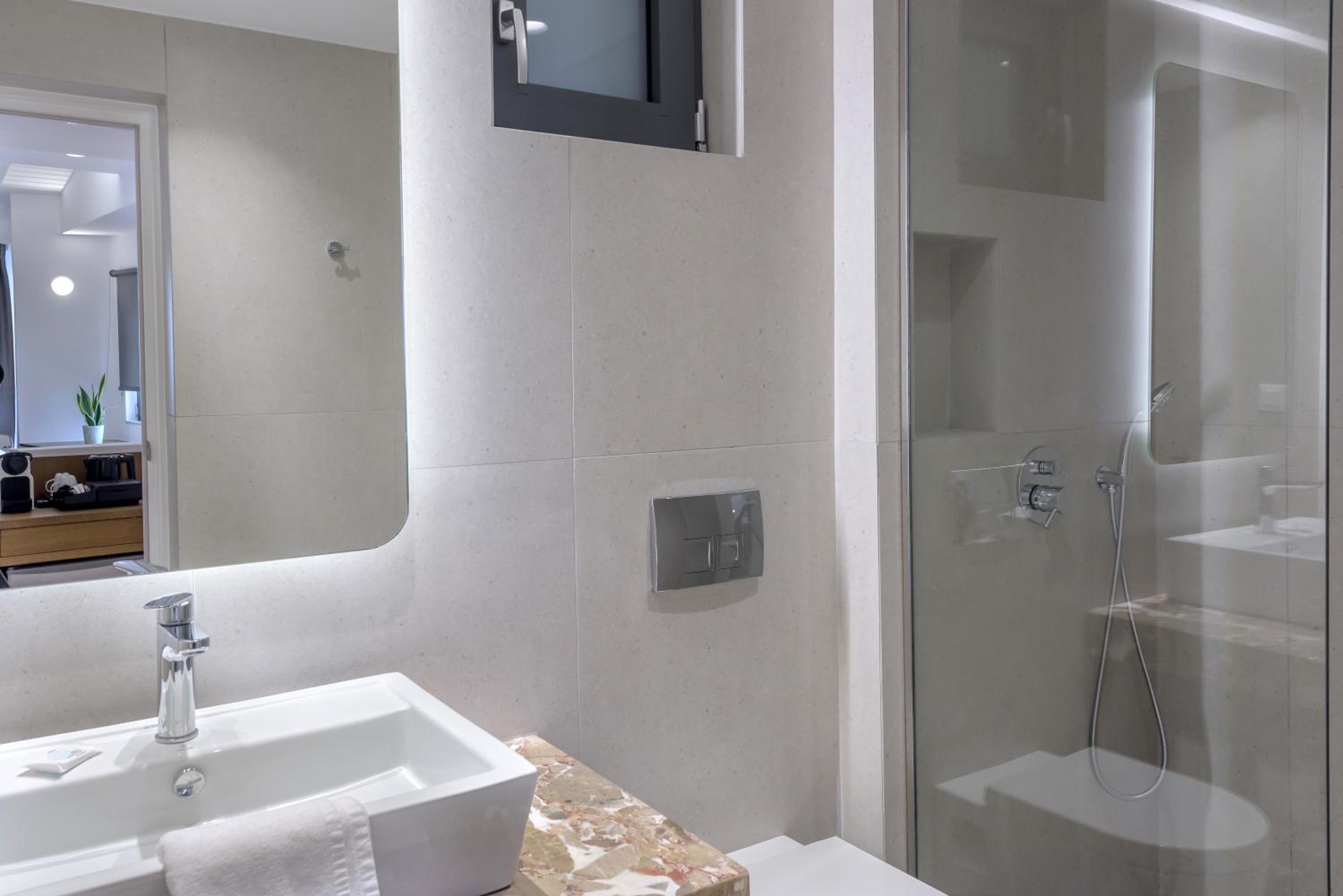 Bathroom with a white sink, large mirror, and glass-enclosed shower.