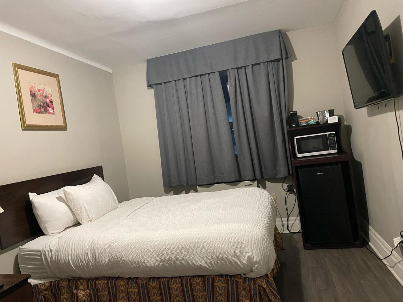 hotel room with a bed, microwave, and television