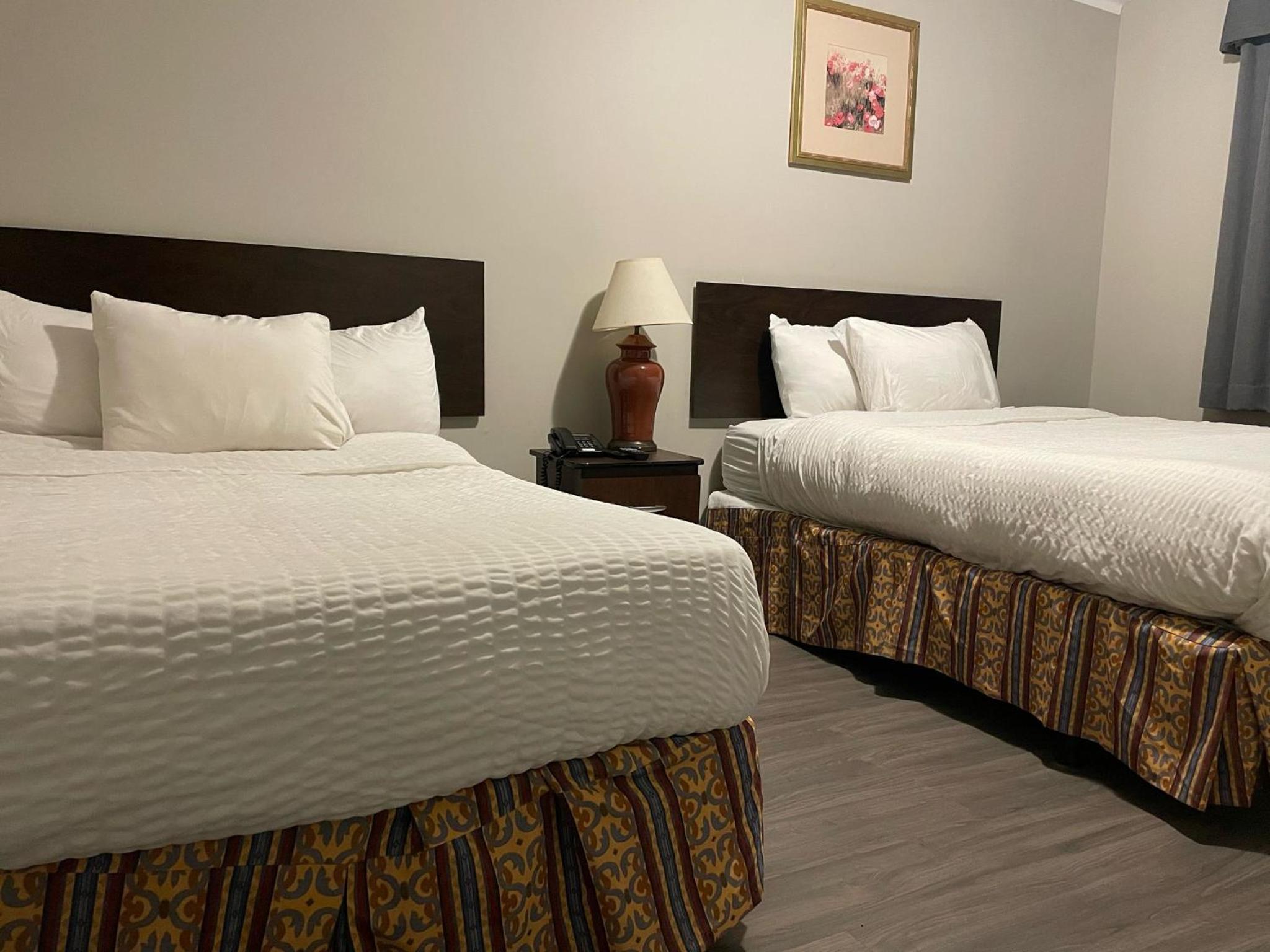 hotel room with two beds and a lamp on the nightstand