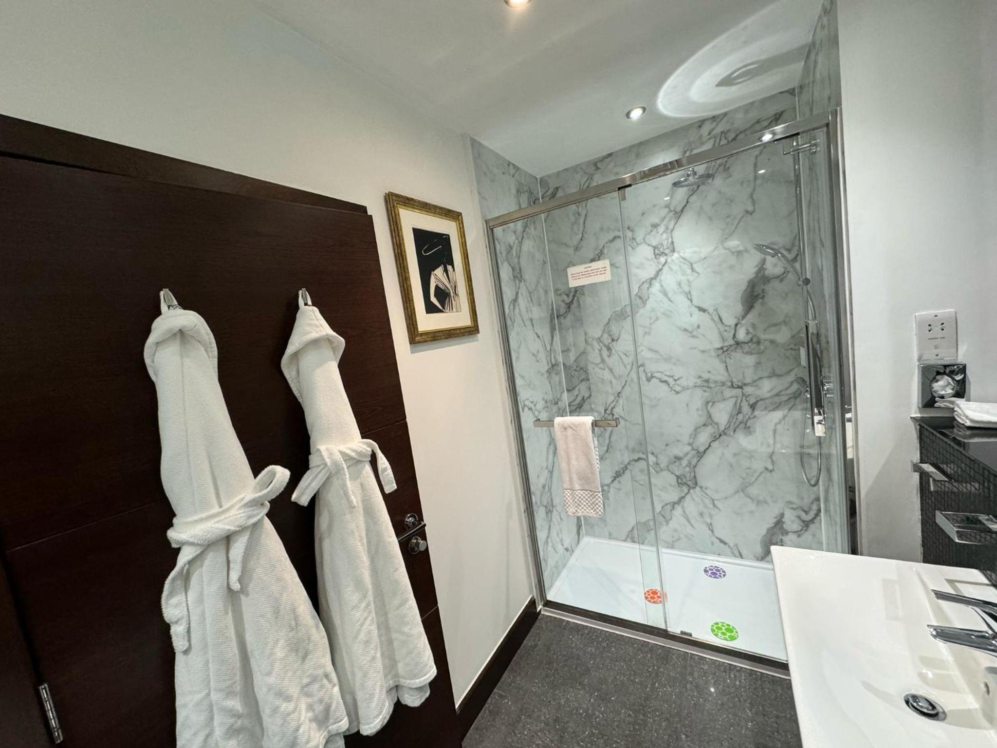 walk - in shower with two towels hanging on the wall