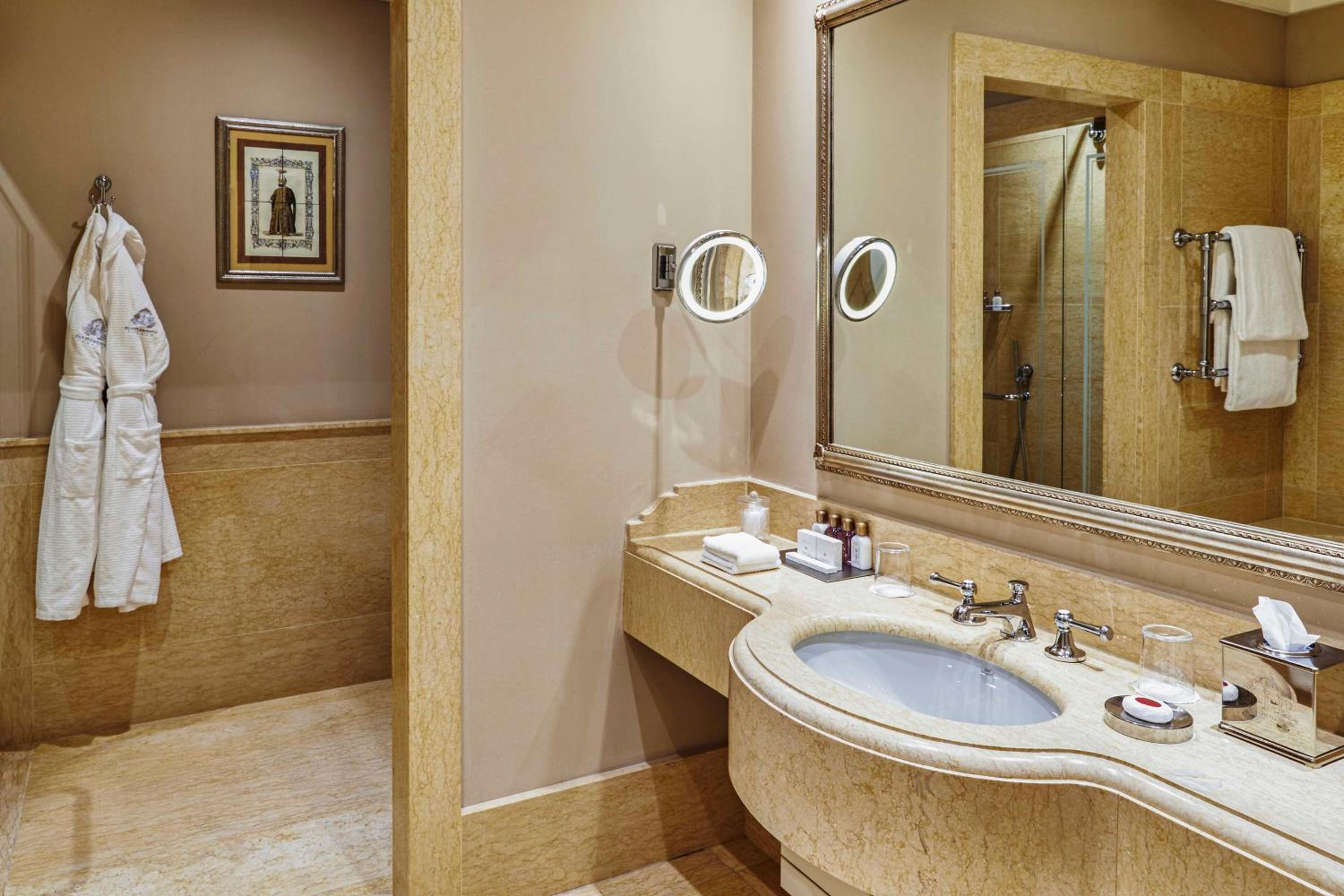bathroom with a sink, shower, and bathrobe