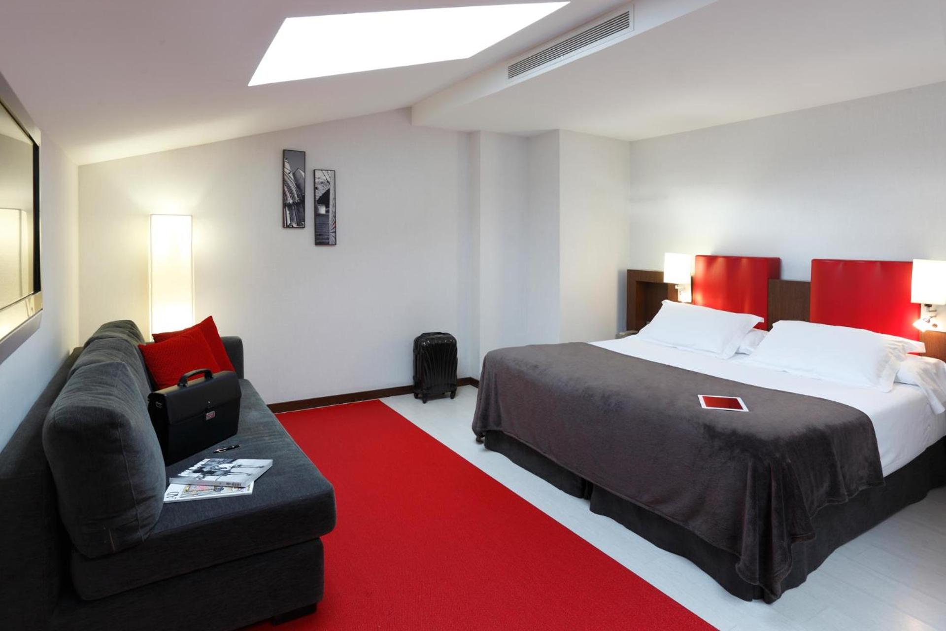 hotel room with a bed, couch, and television