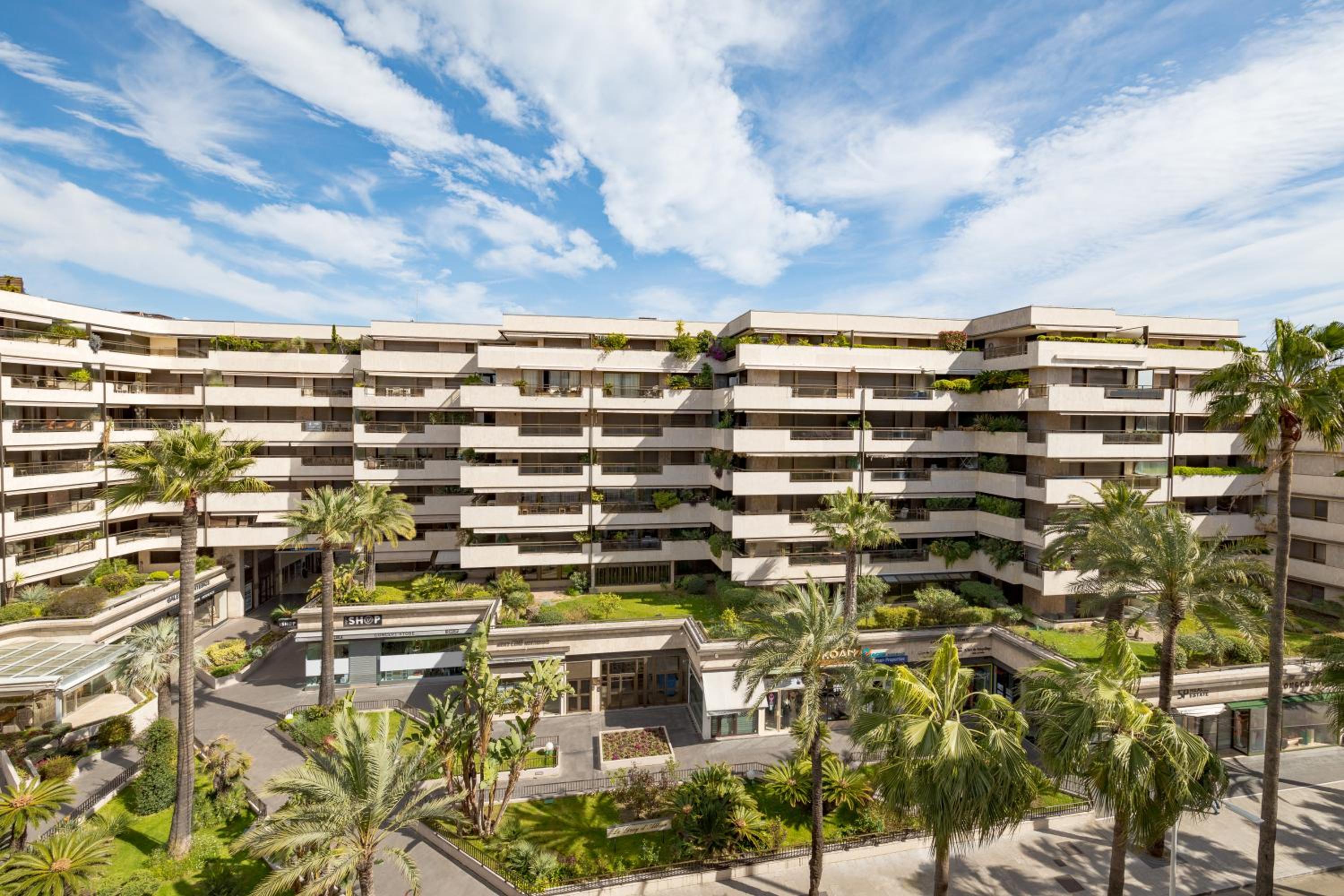 view of an apartment complex with palm trees in the foreground