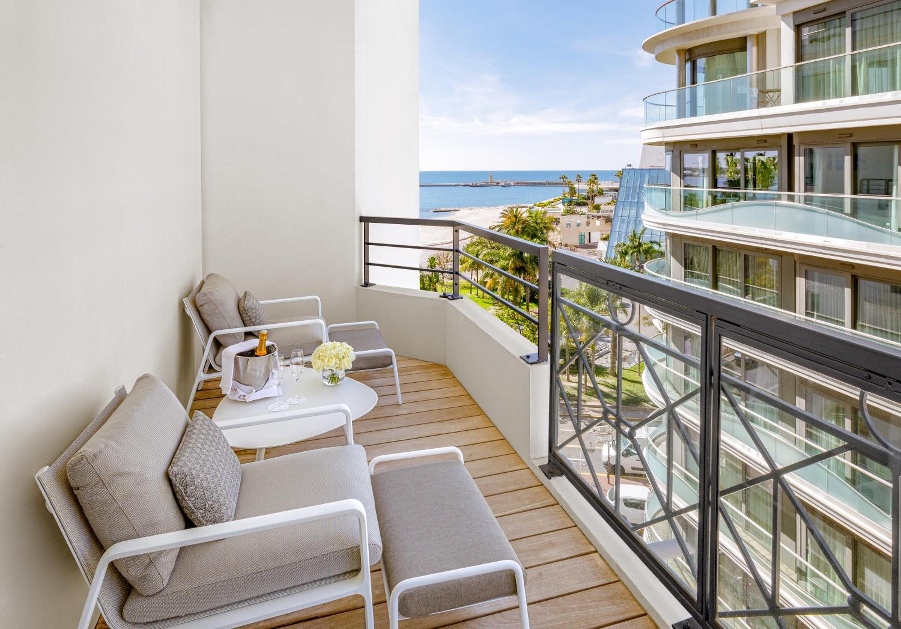 balcony with two chairs and a table overlooking the ocean
