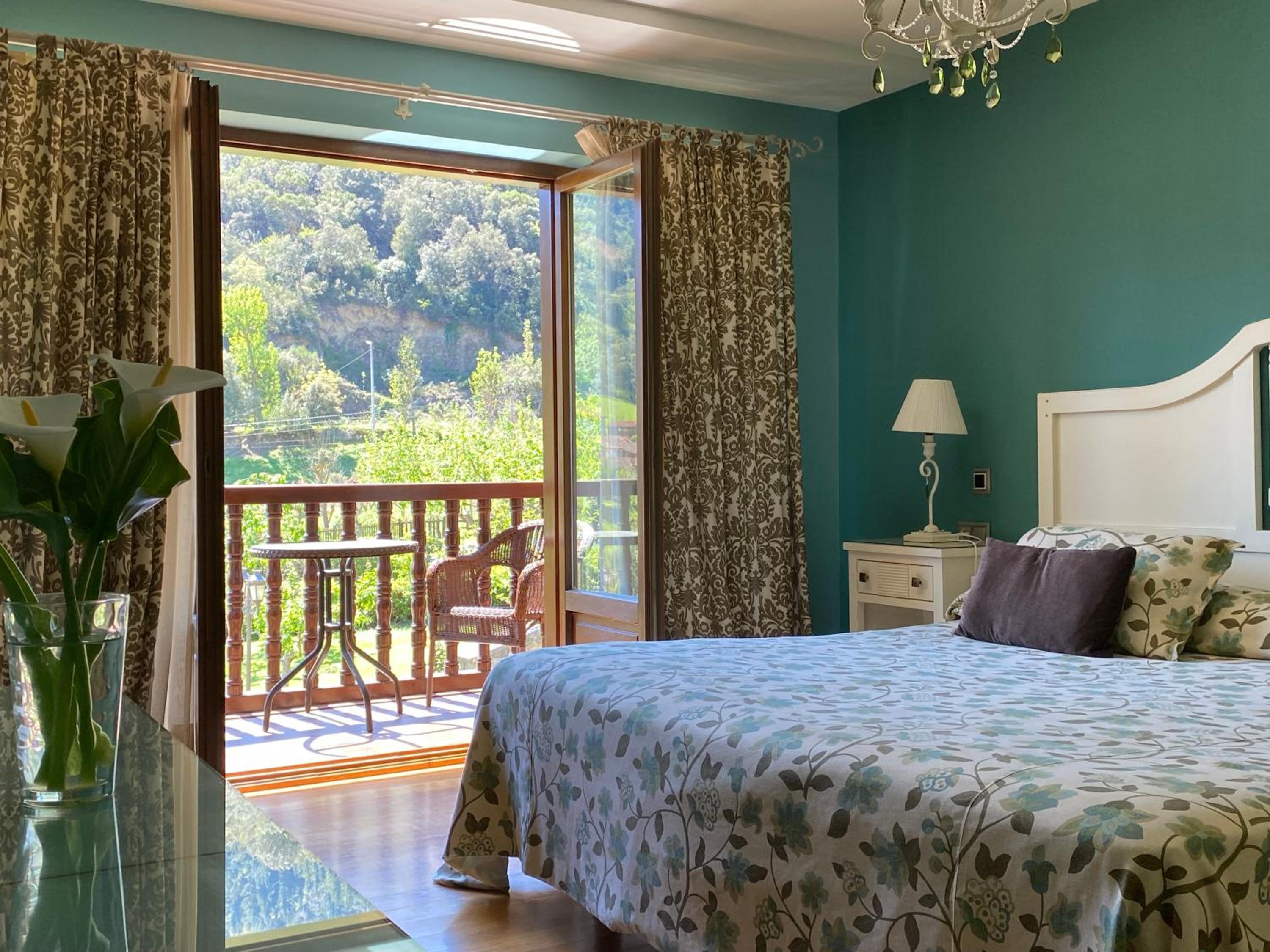 King Superior con cama king, bañera de hidromasaje y terraza con vistas a la montaña.