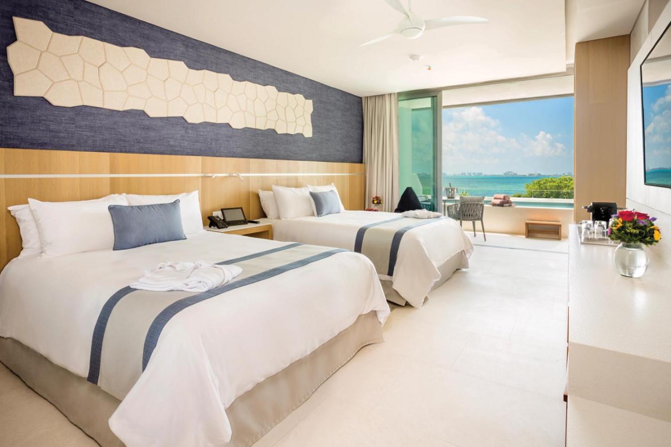 Habitación Prefered Club Deluxe con vista al océano y piscina de inmersión con 2 camas Queen.