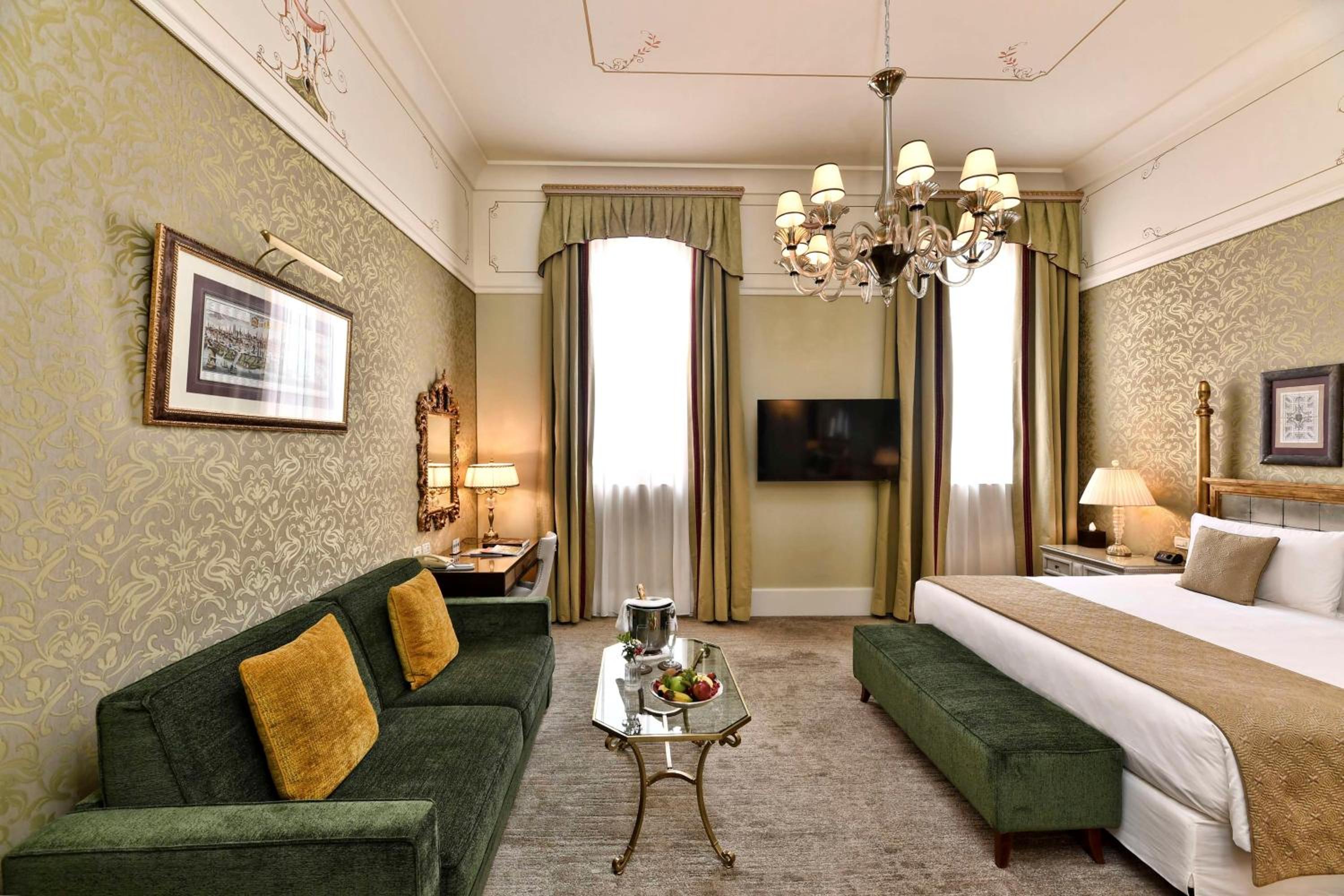 hotel room with a king size bed and green couch