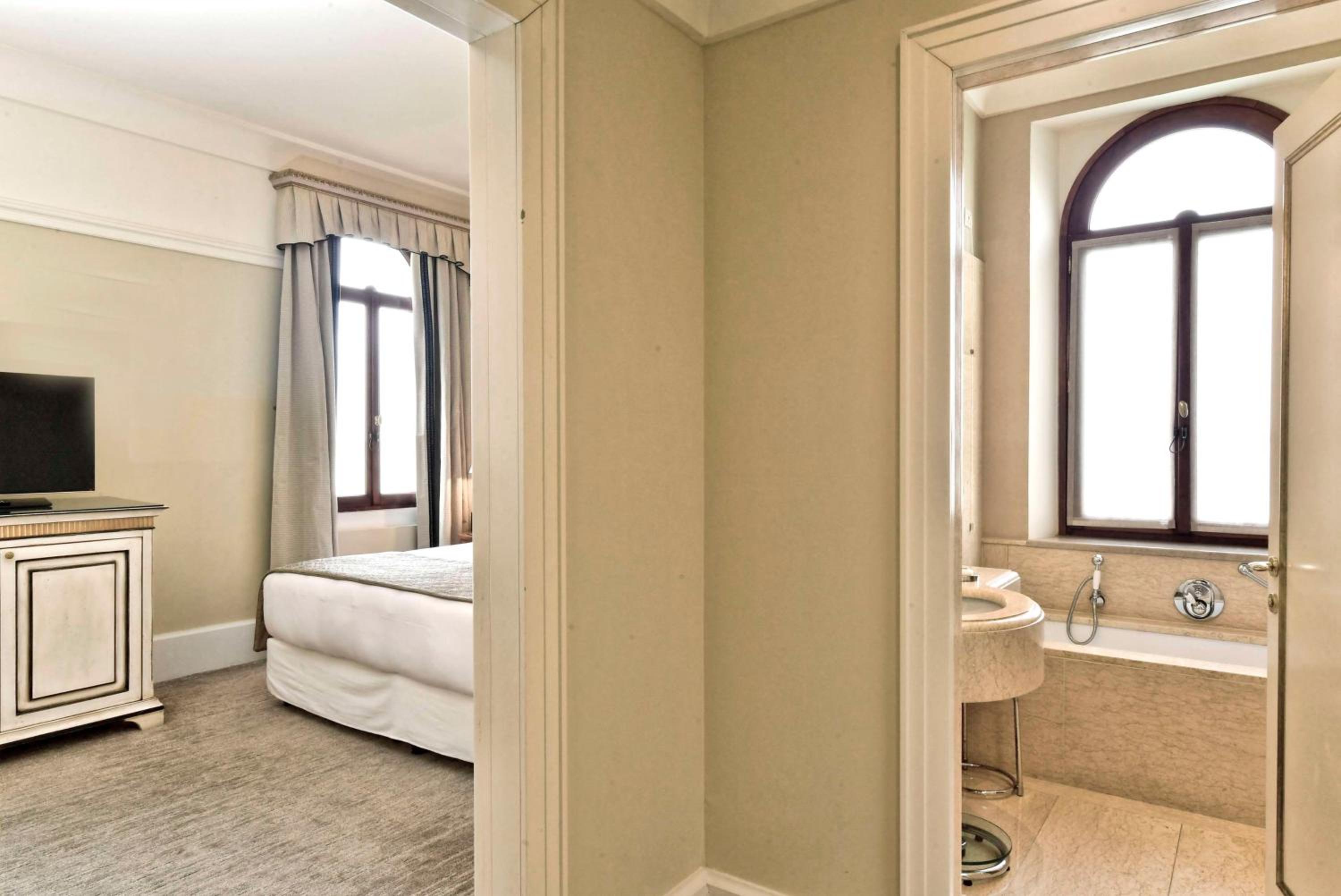 view of a bedroom with a tv and a bathtub