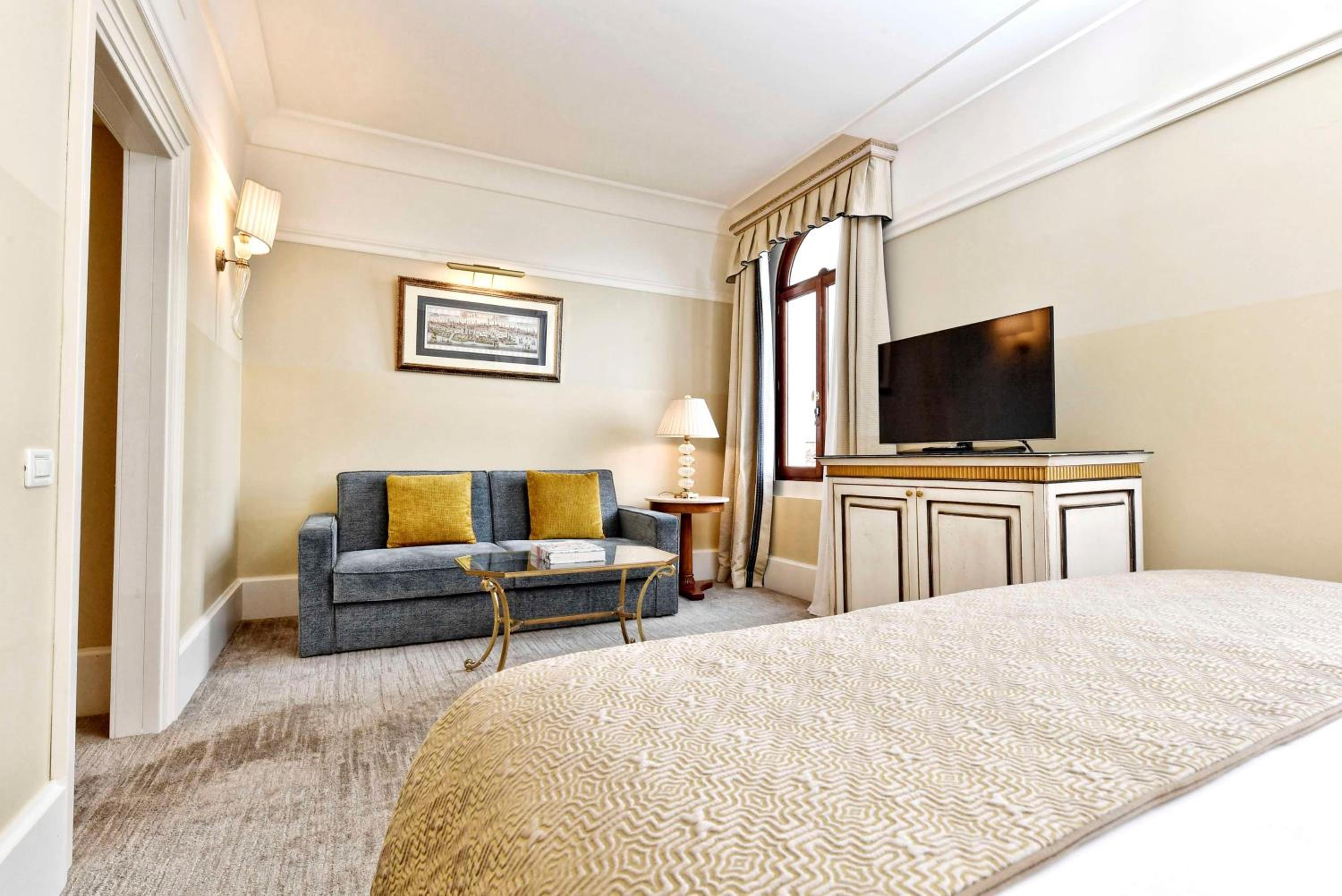hotel room with a bed, couch, and television