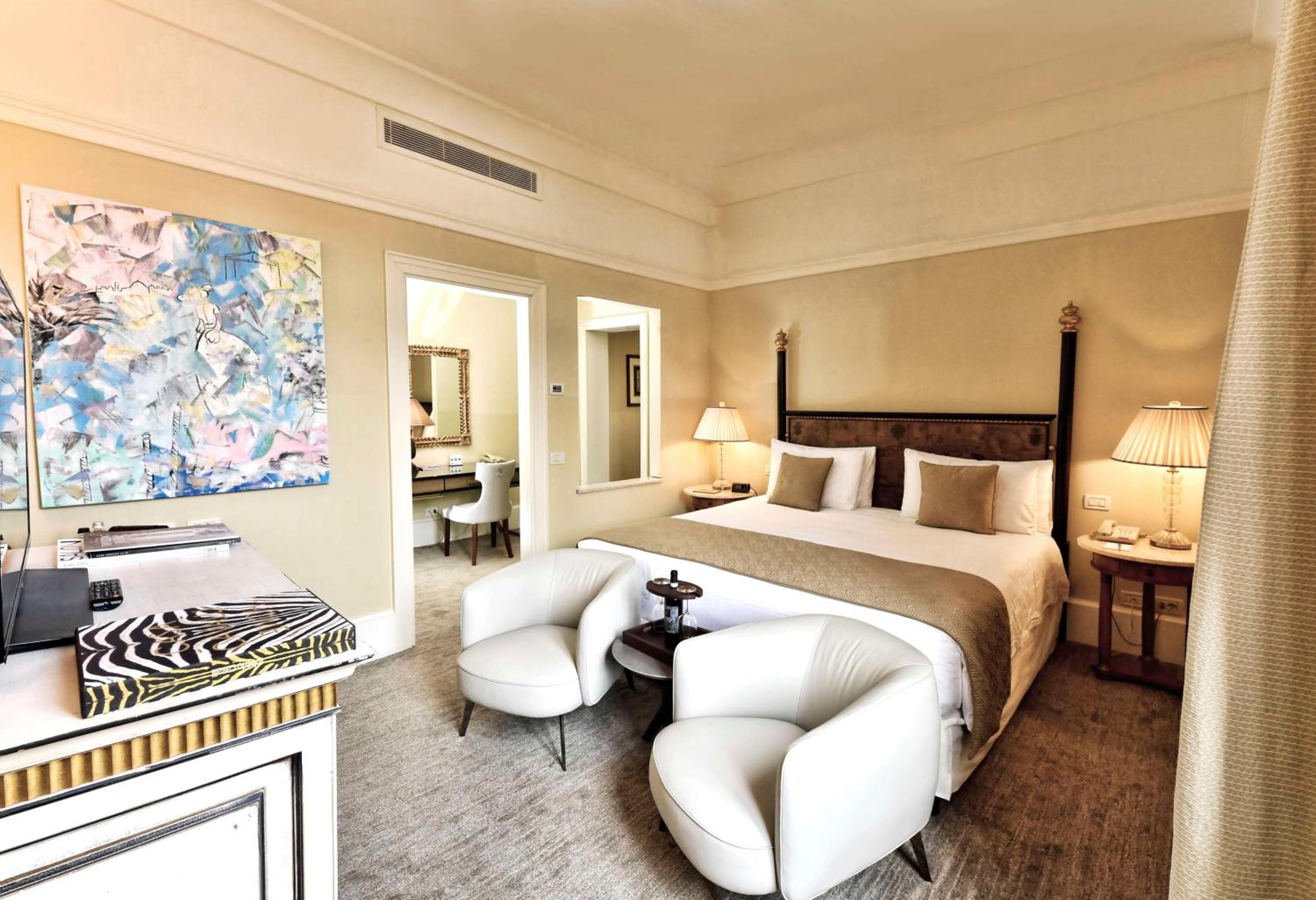 hotel room with a king size bed and two chairs