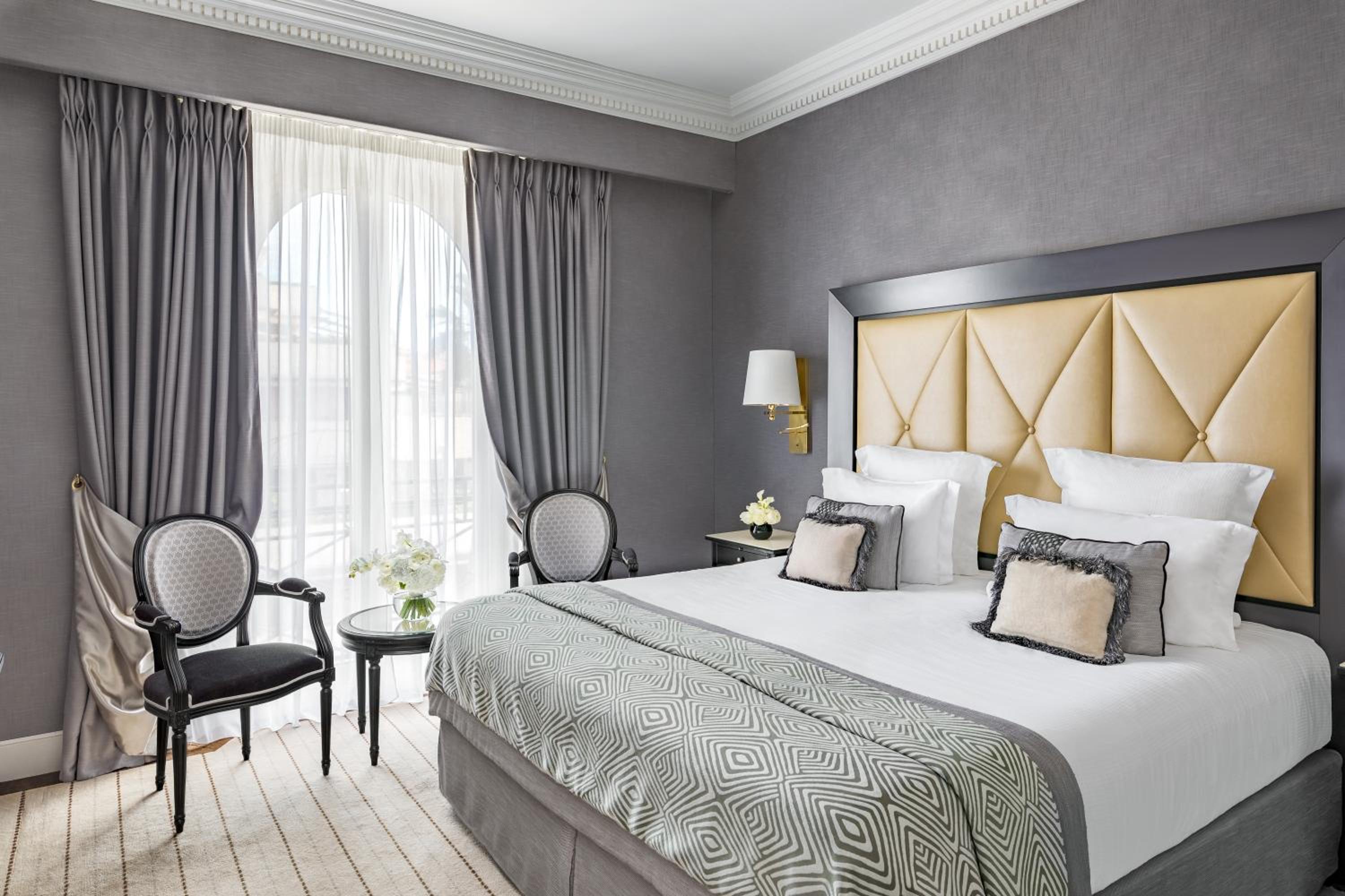 hotel room with a king size bed and two chairs