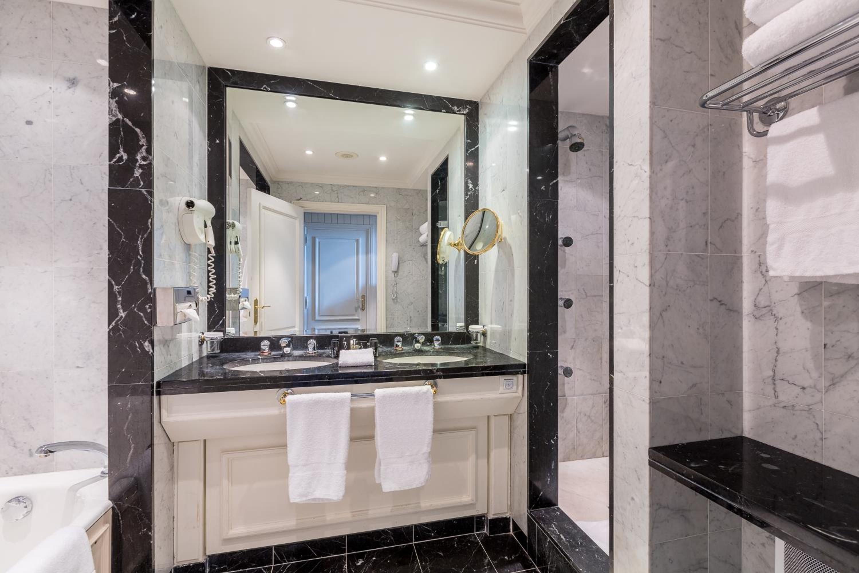 black and white marble bathroom with a large mirror over the sink