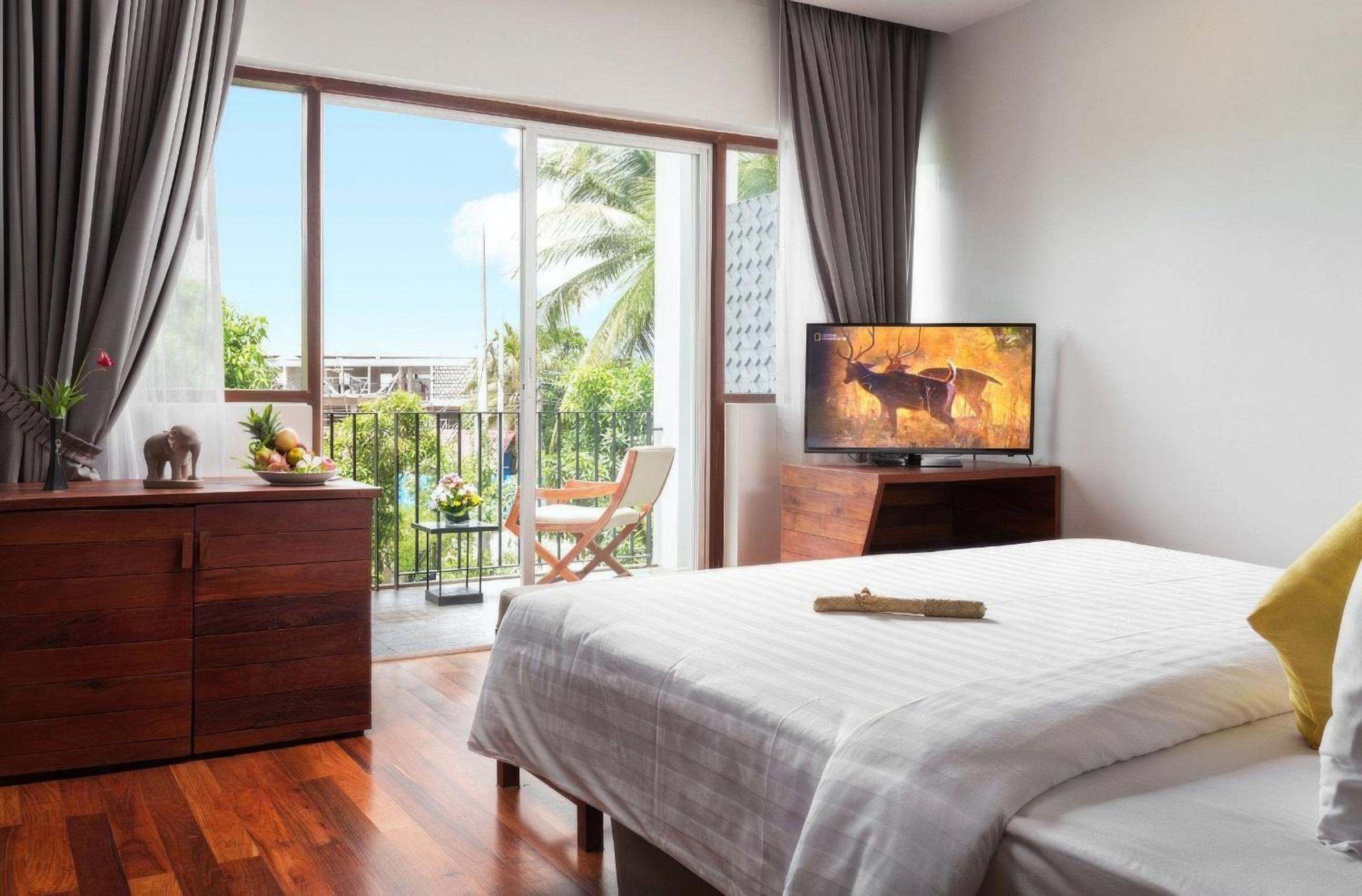 Junior King Suite City View with Balcony, Sofa Area, and Bathtub