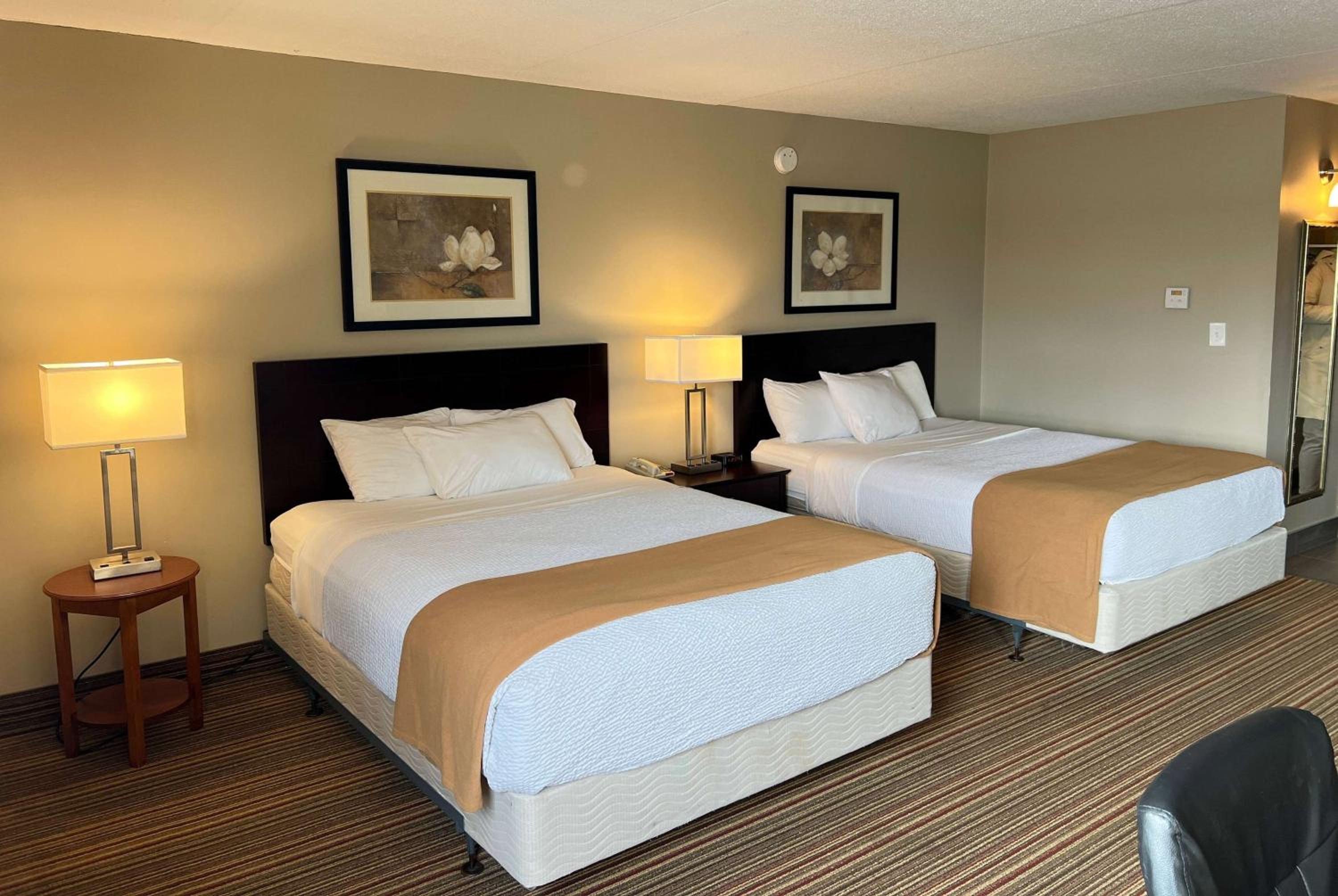 hotel room with two beds and a desk in the corner