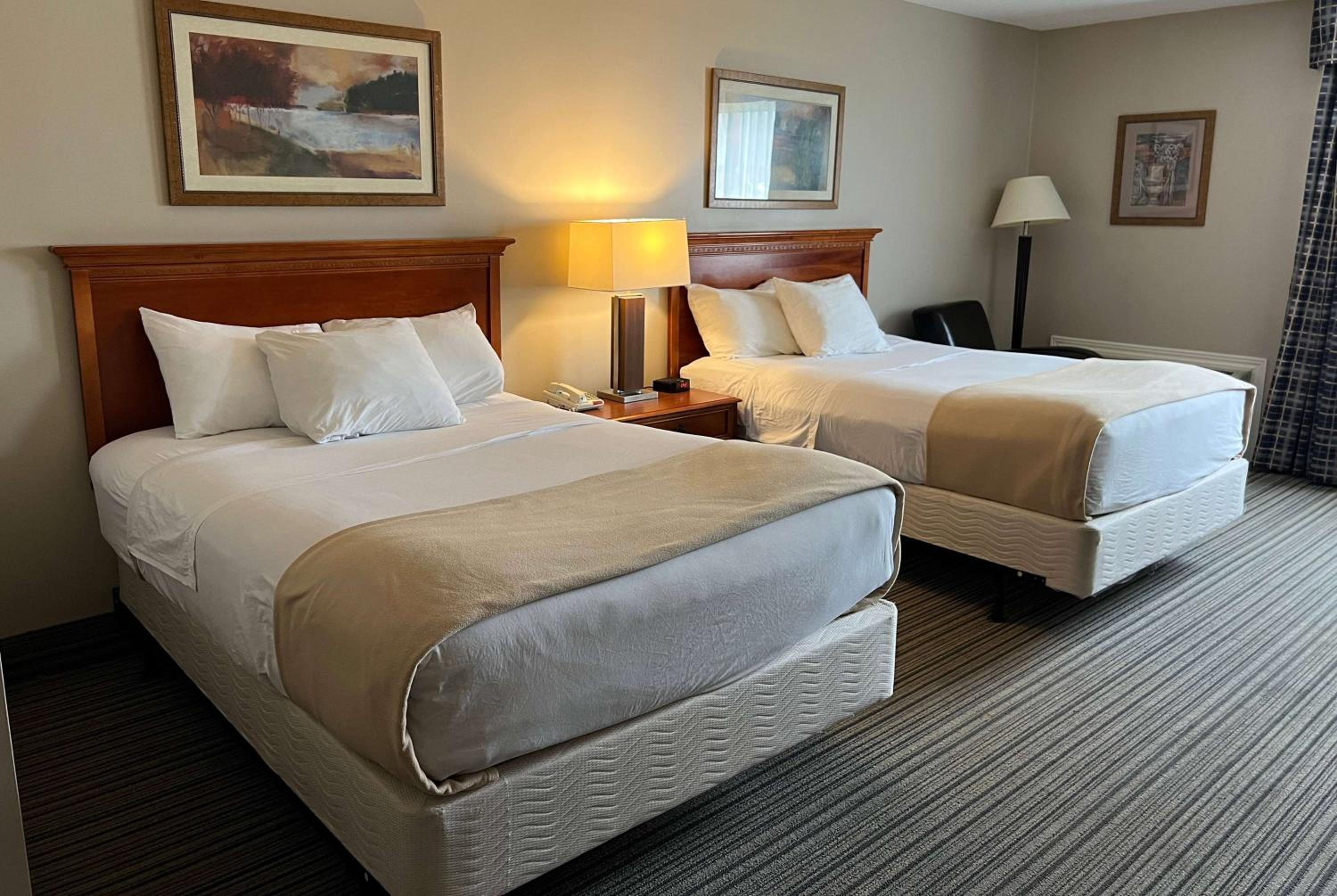 hotel room with two beds and a desk in the corner