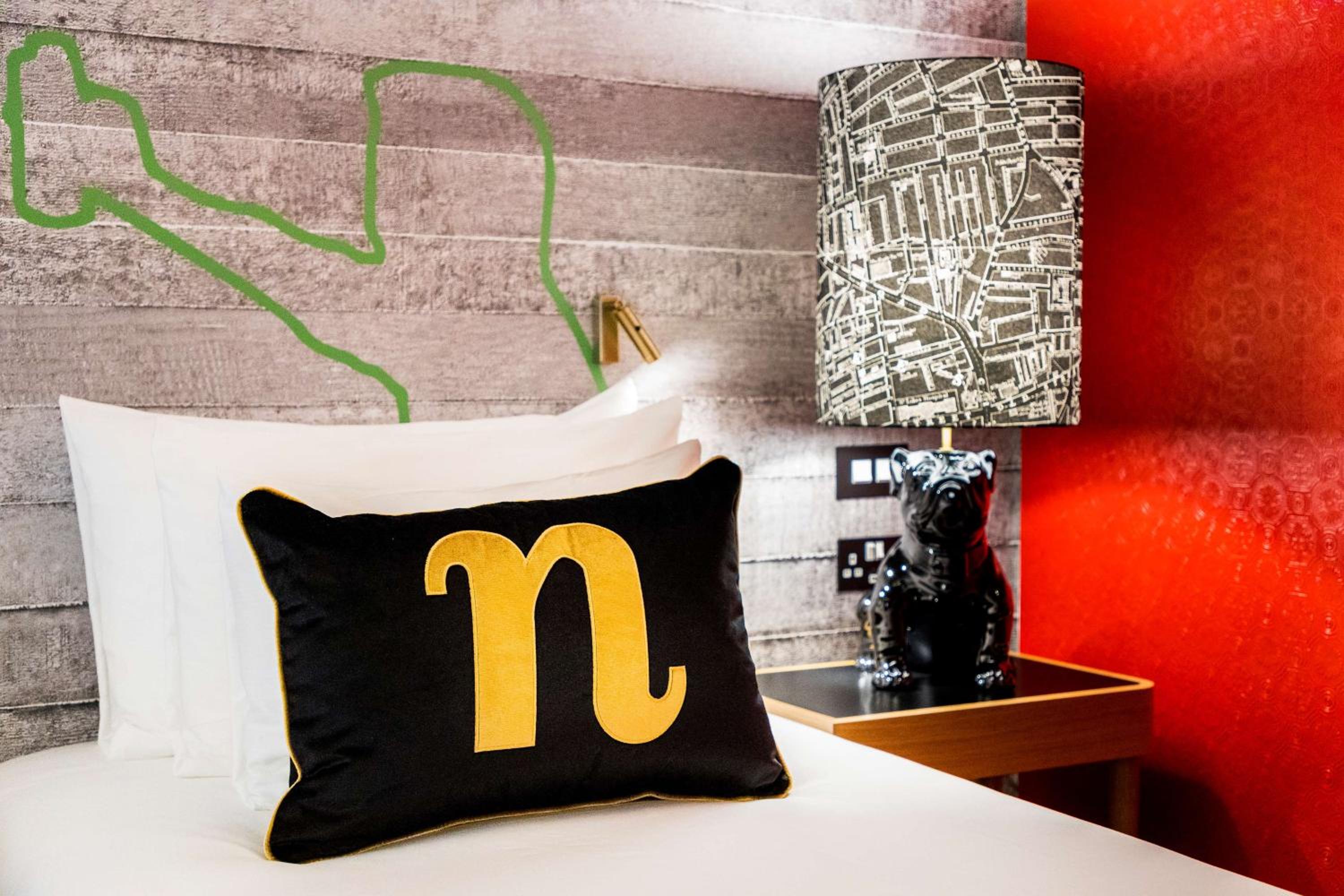 bed with a black and yellow pillow on top of it