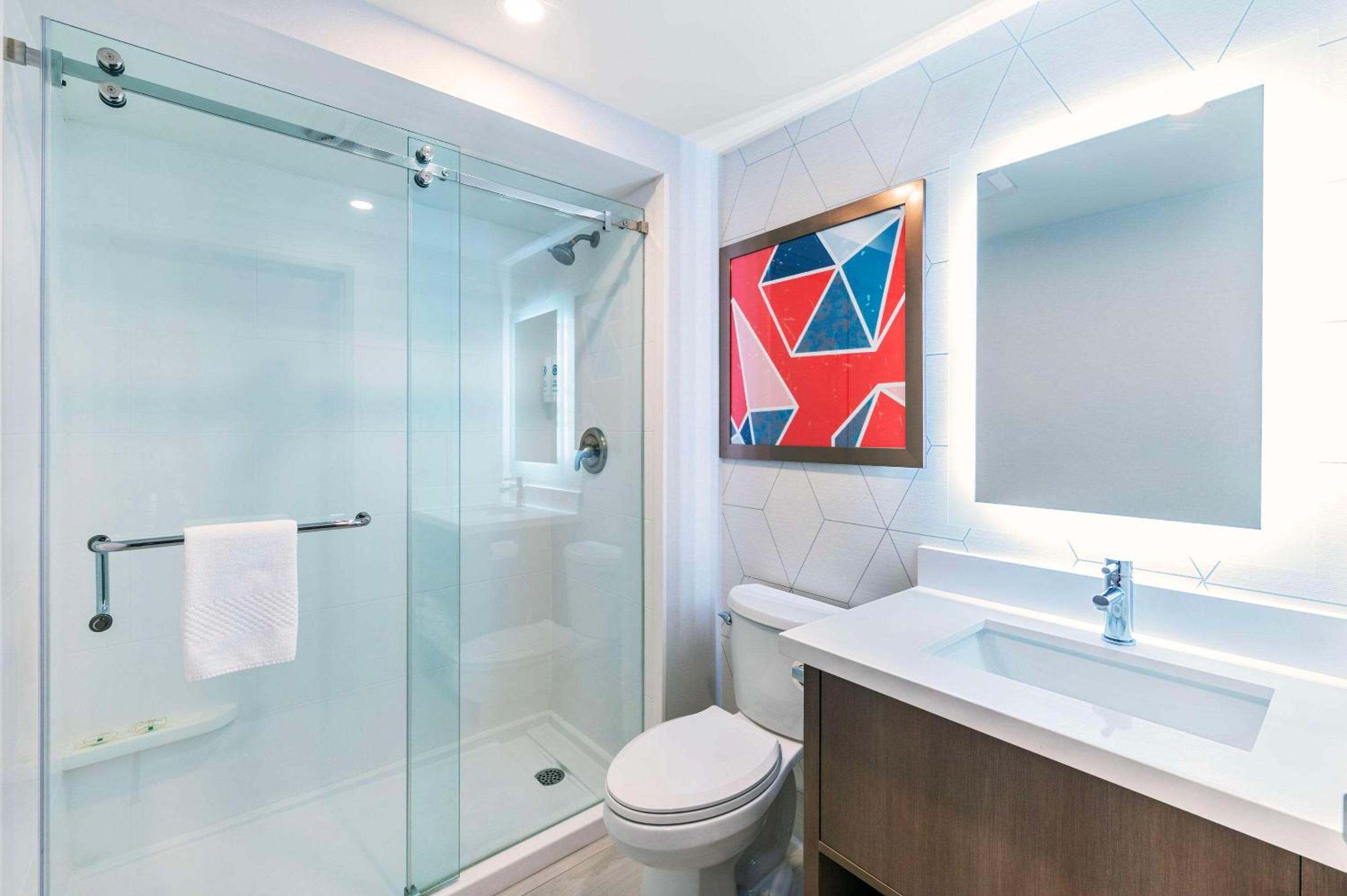bathroom with a toilet, sink, and shower stall