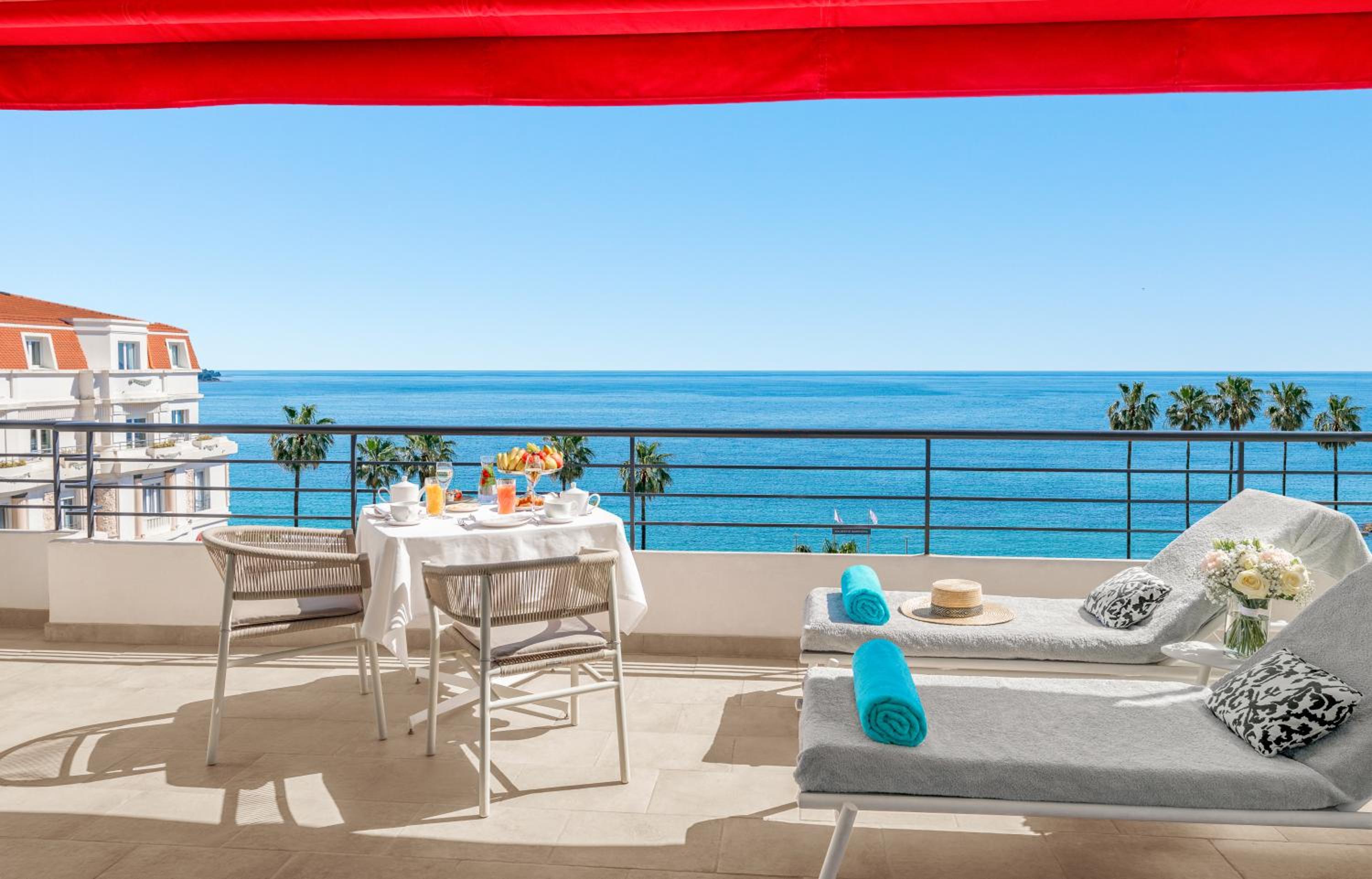 balcony with a table and chairs overlooking the ocean?