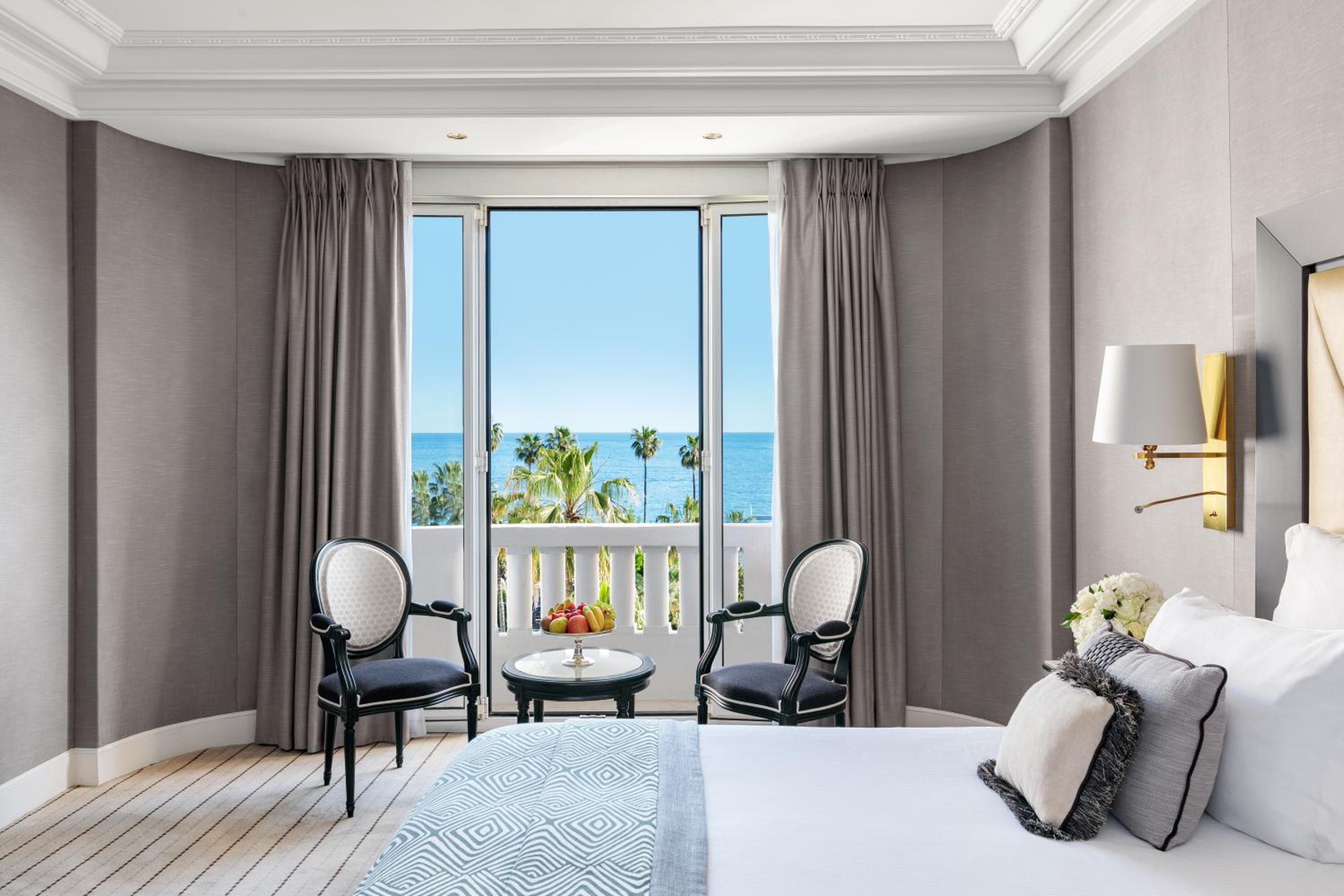 hotel room with a view of the ocean and palm trees