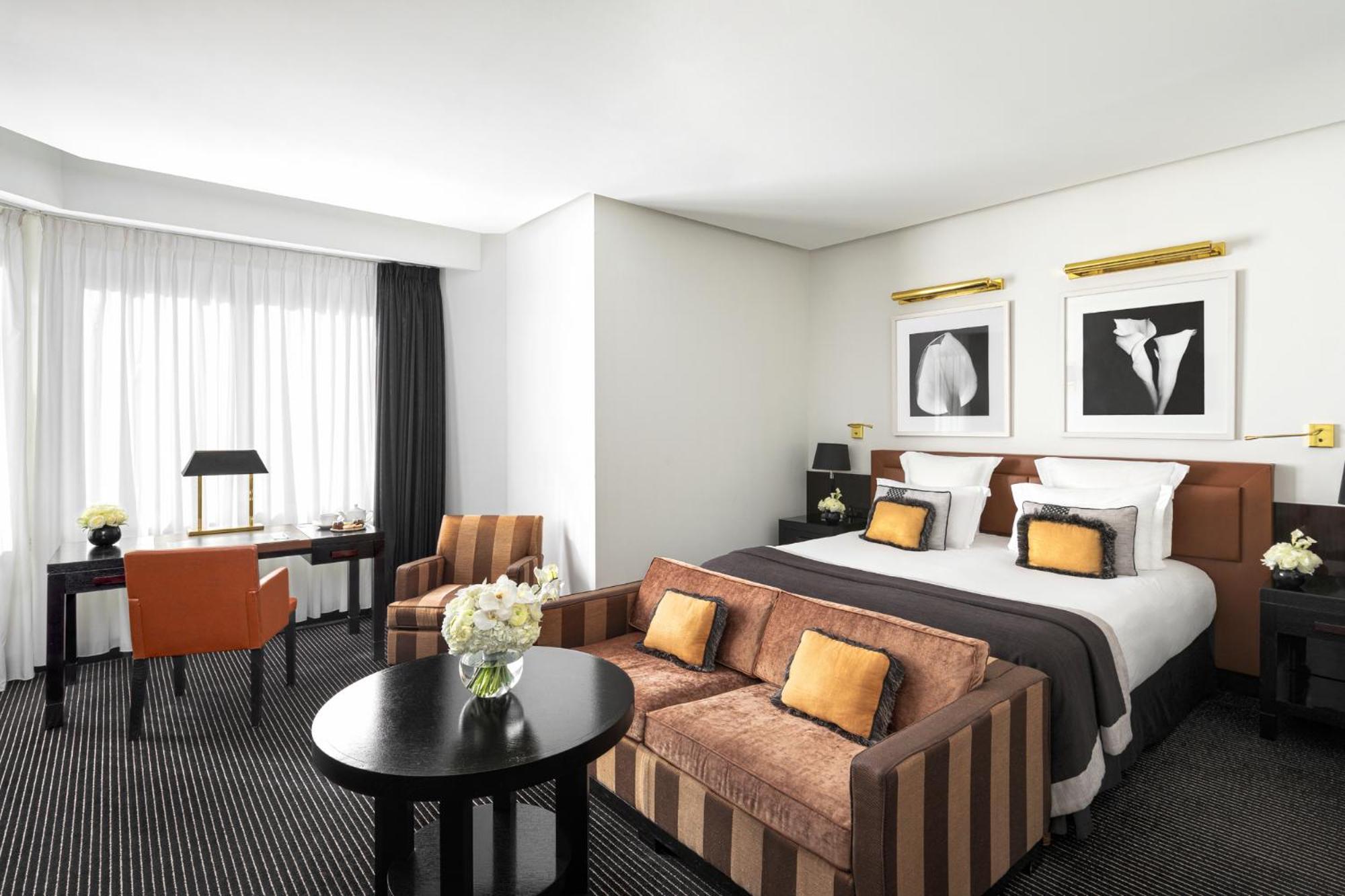 hotel room with a bed, couch, and coffee table