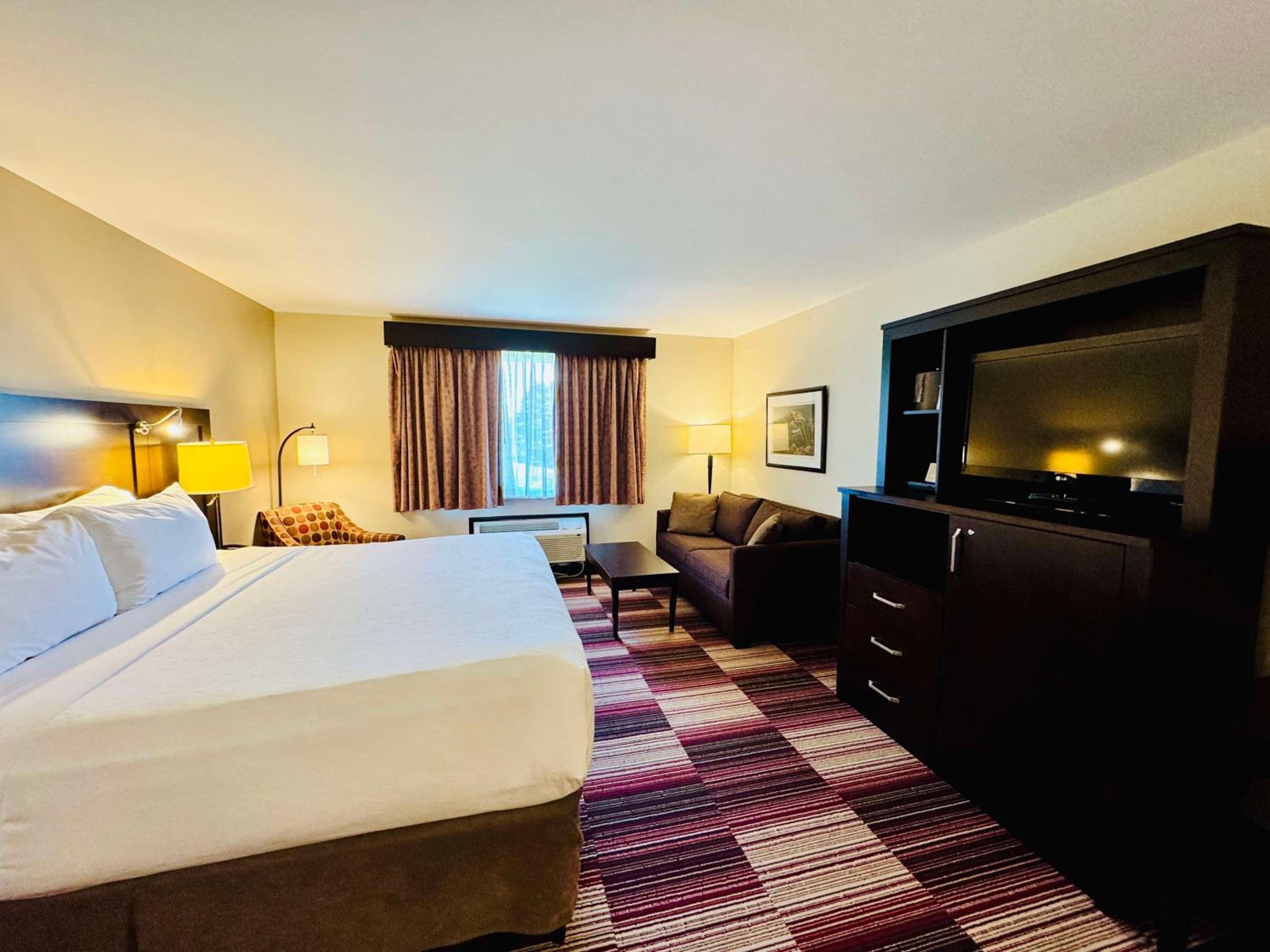 hotel room with a king bed and a flat screen tv