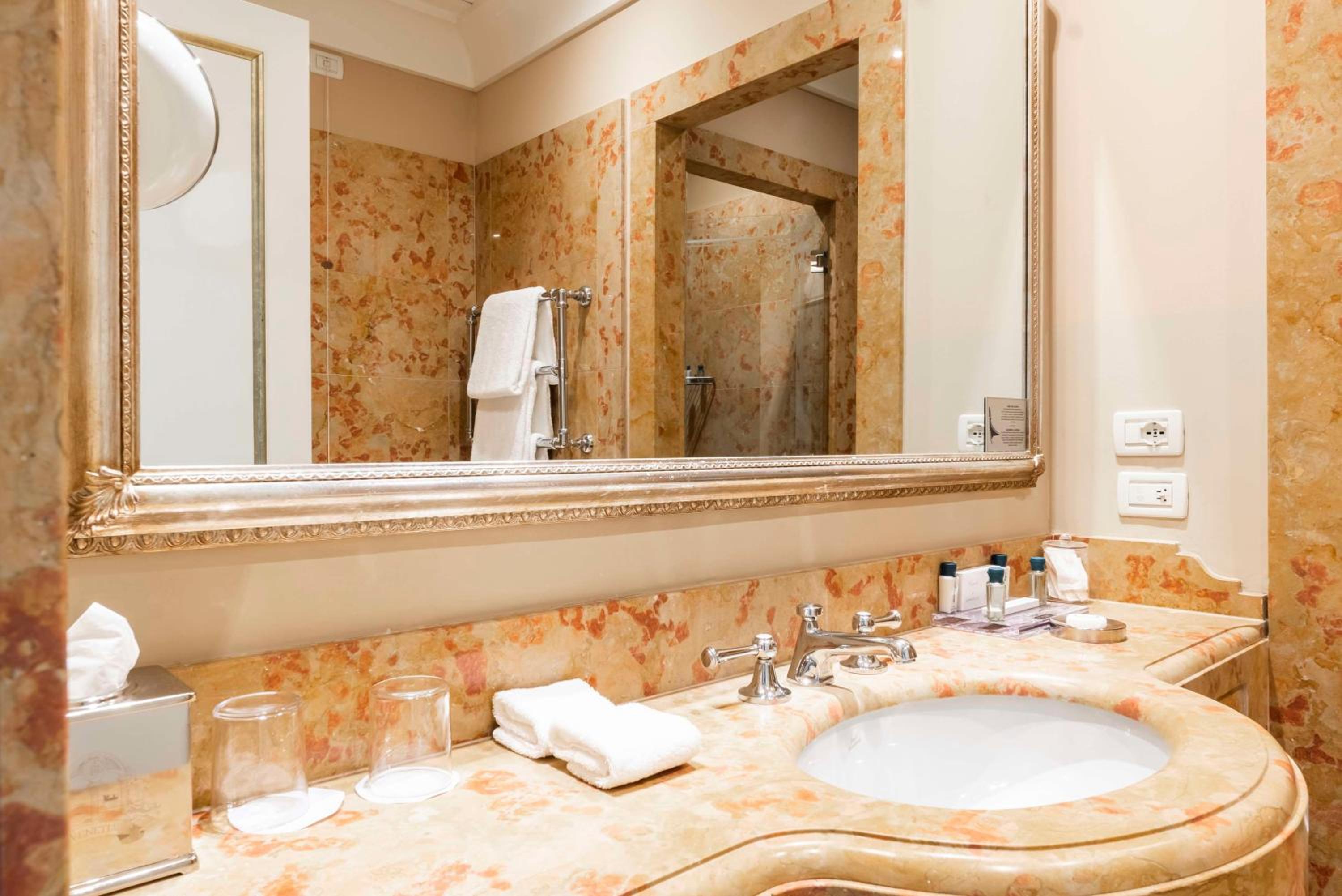 bathroom with a marble counter top and a large mirror