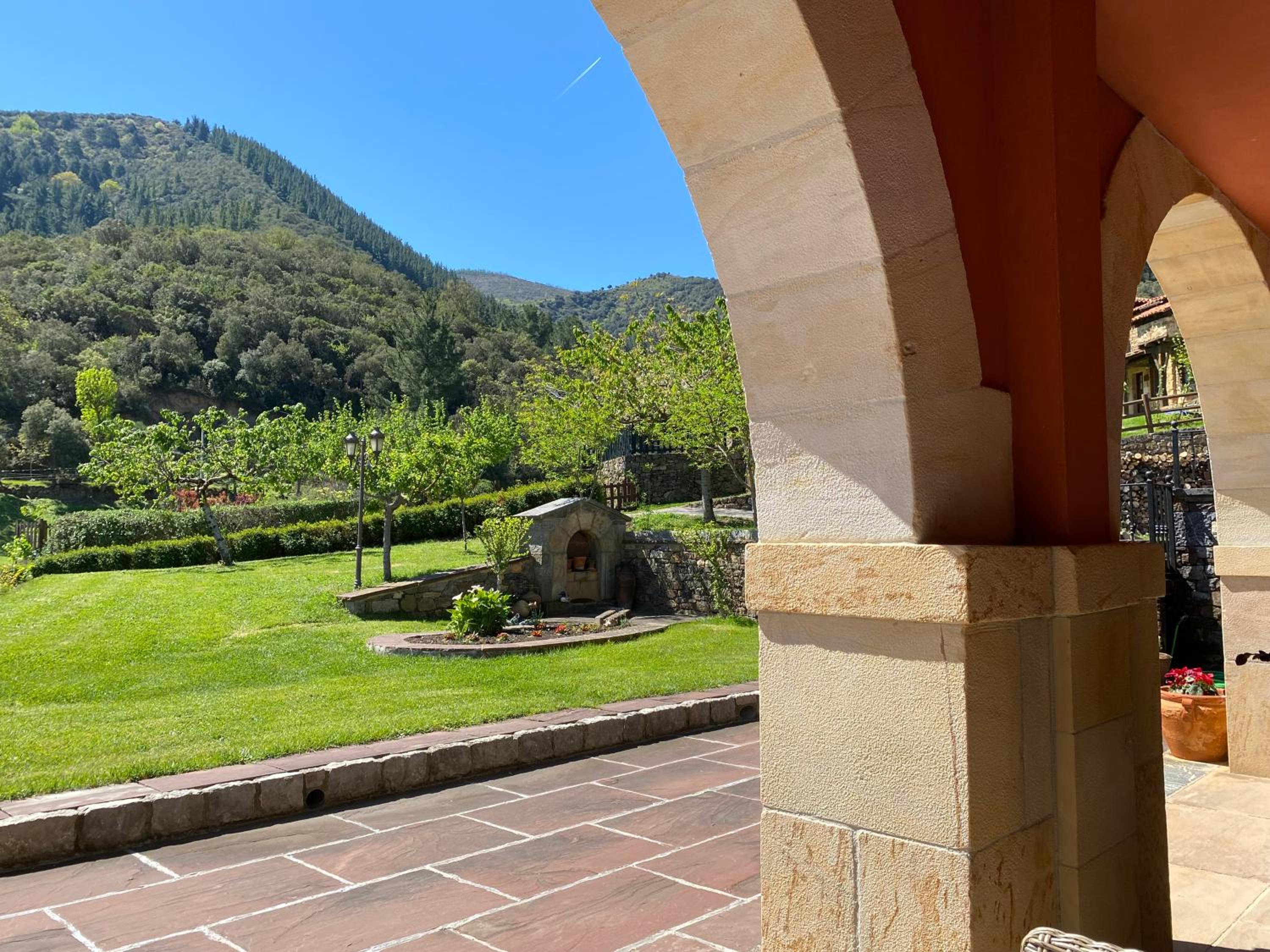 Habitación Doble con cama matrimonial grande, bañera de hidromasaje y terraza con vistas a la montaña.