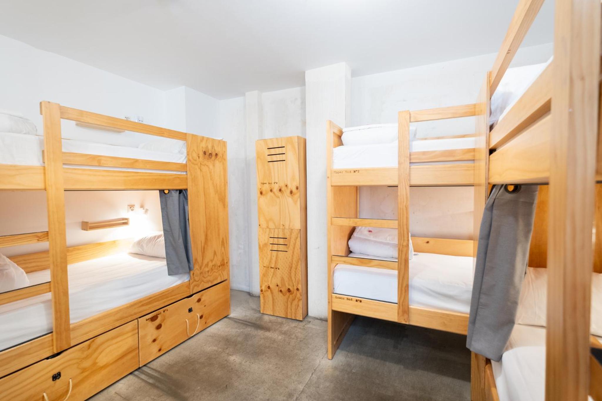 Cama individual en dormitorio compartido de 6 camas con baño privado.
