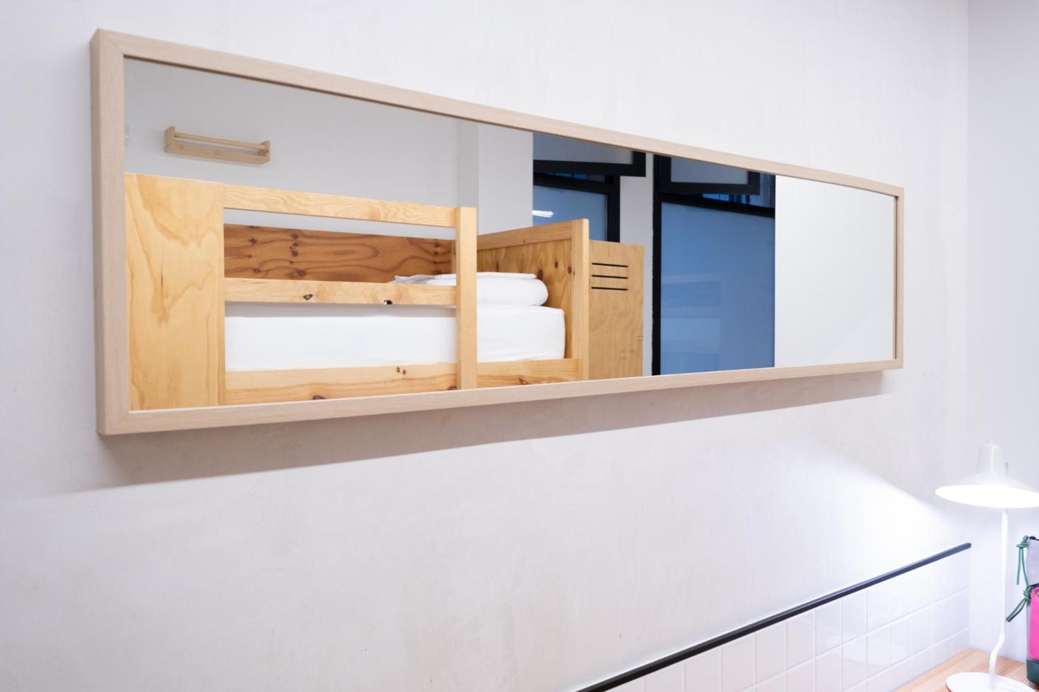 Cama individual en dormitorio compartido mixto de 4 camas con baño compartido.