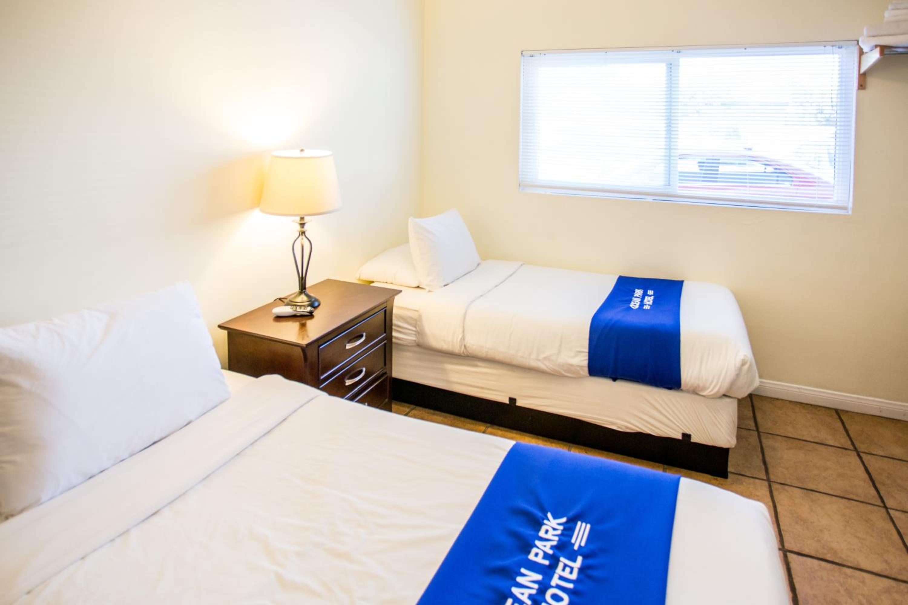 Two single beds with blue runners in a hotel room