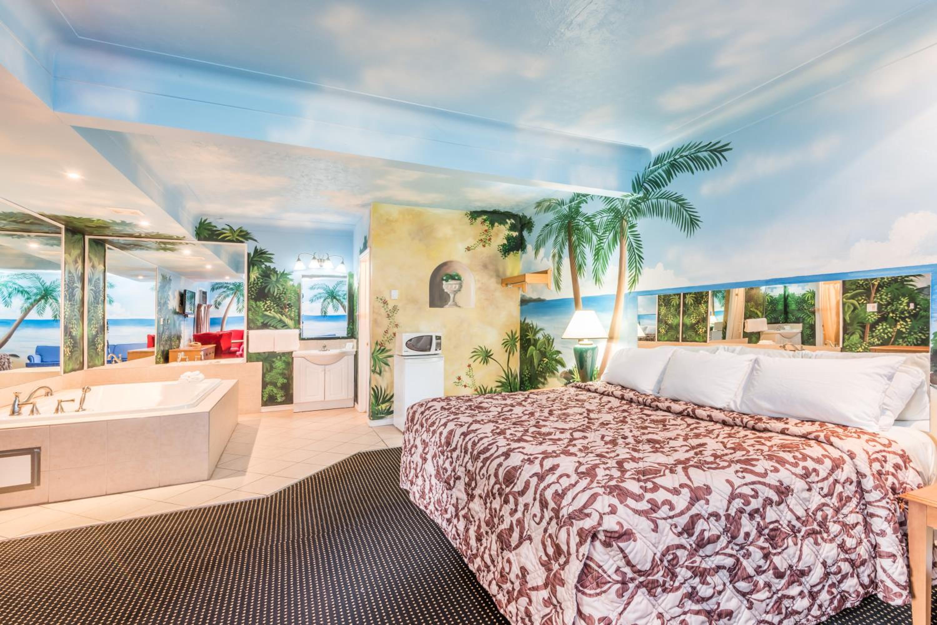 bedroom with a view of the ocean and palm trees