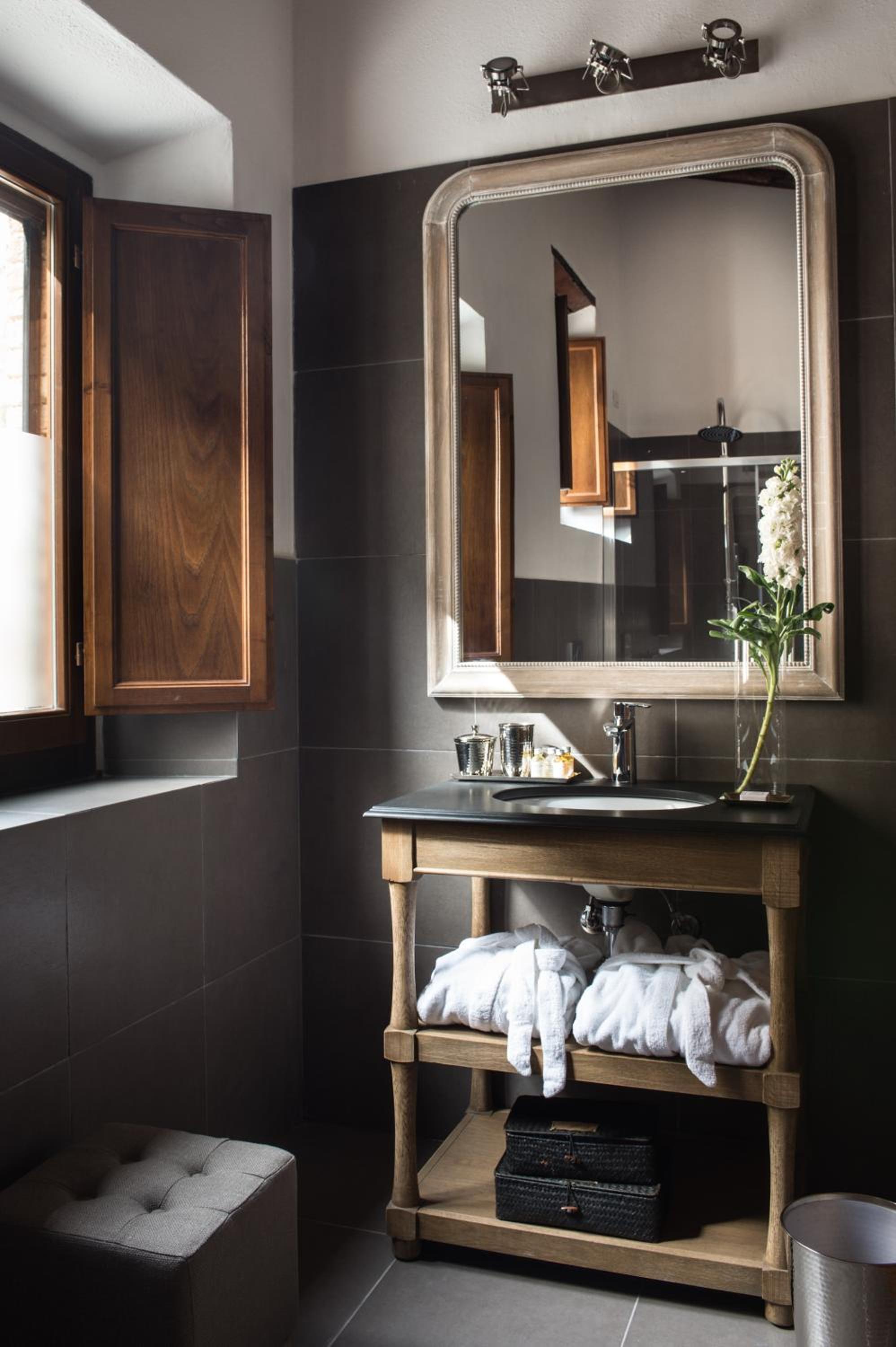 black and white bathroom with a large mirror over the sink