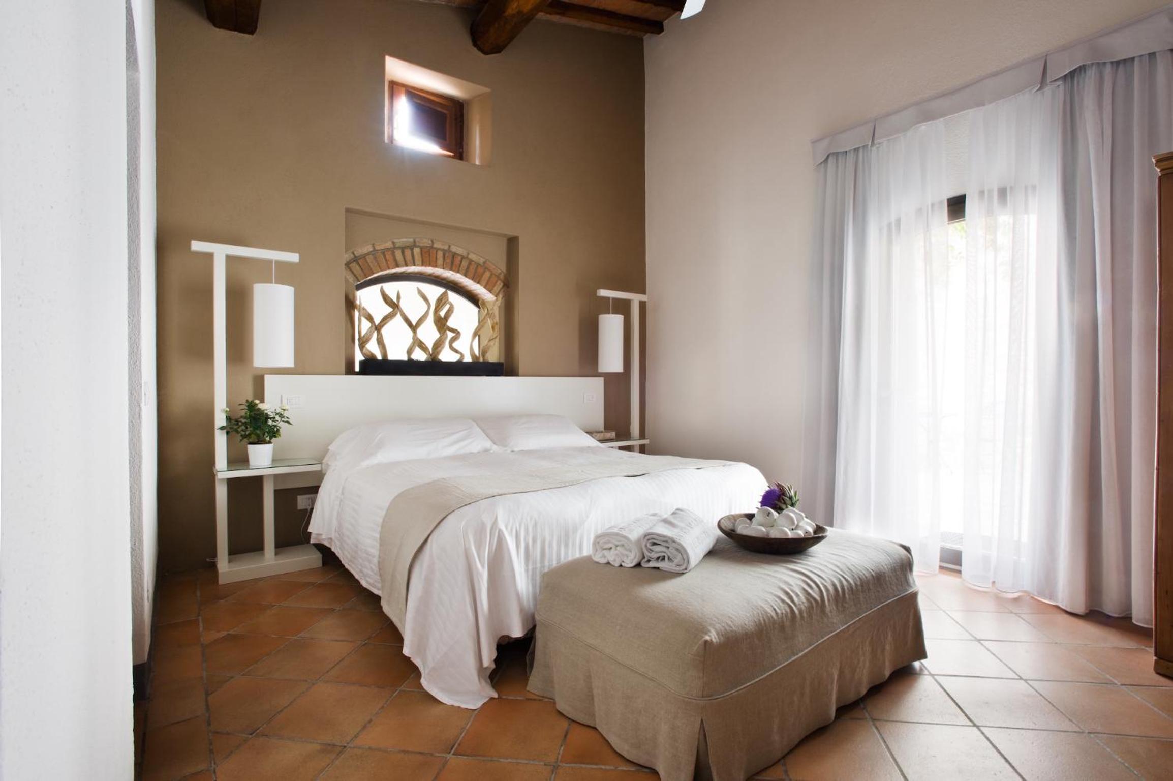 bedroom with a large bed and a small foot stool