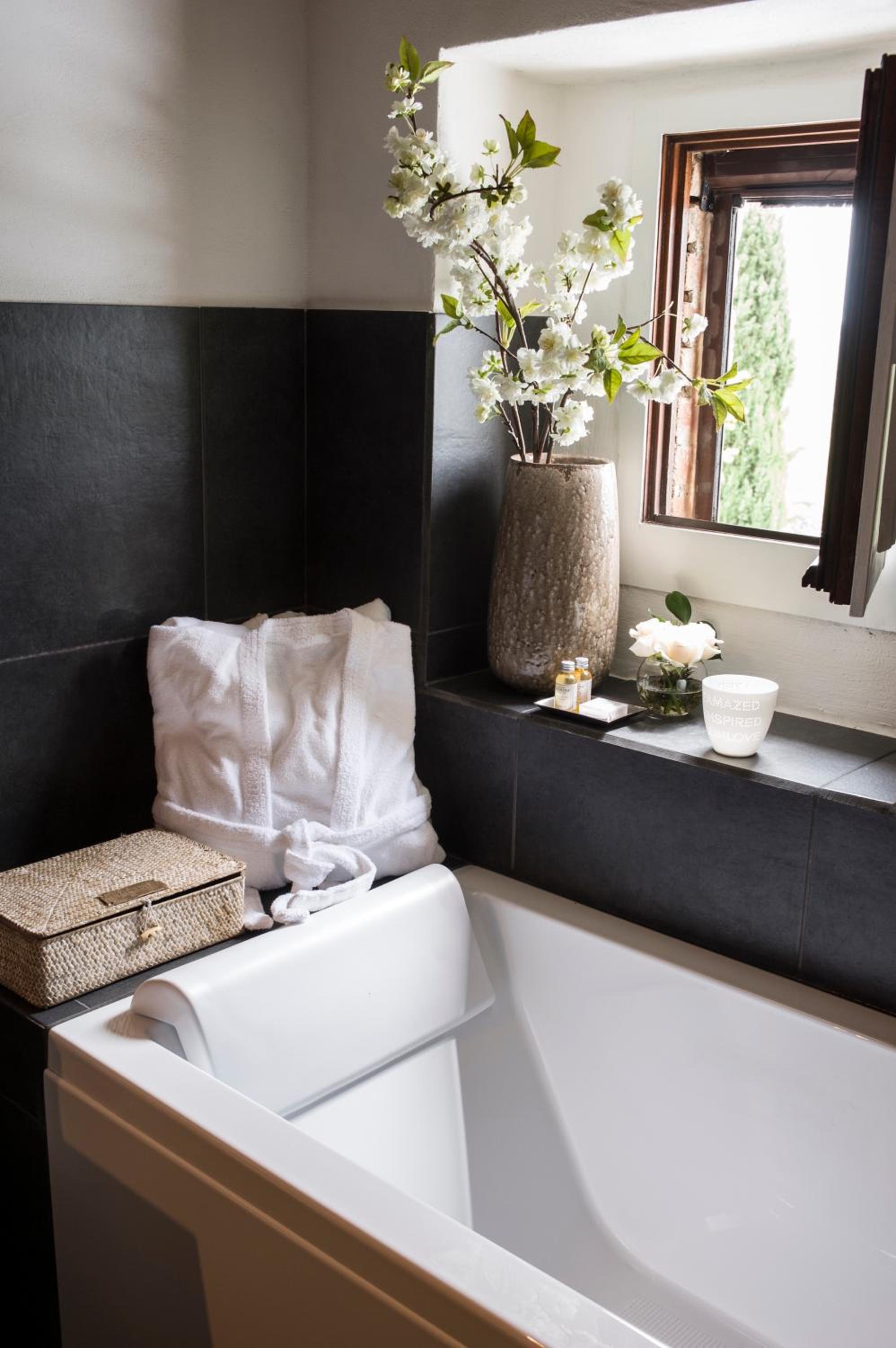 white bathtub in a black and white tiled bathroom