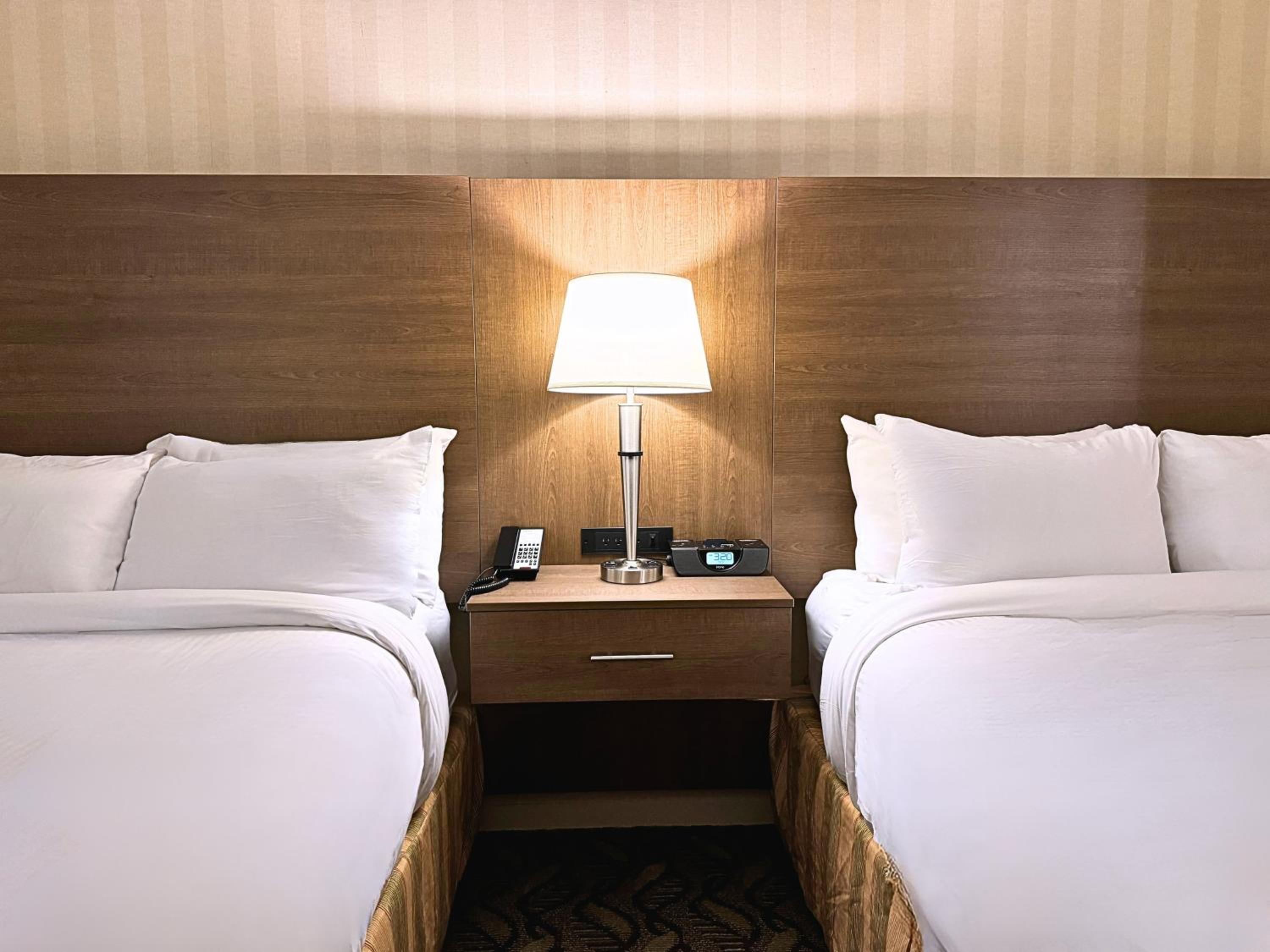 hotel room with two beds and a phone on the nightstand