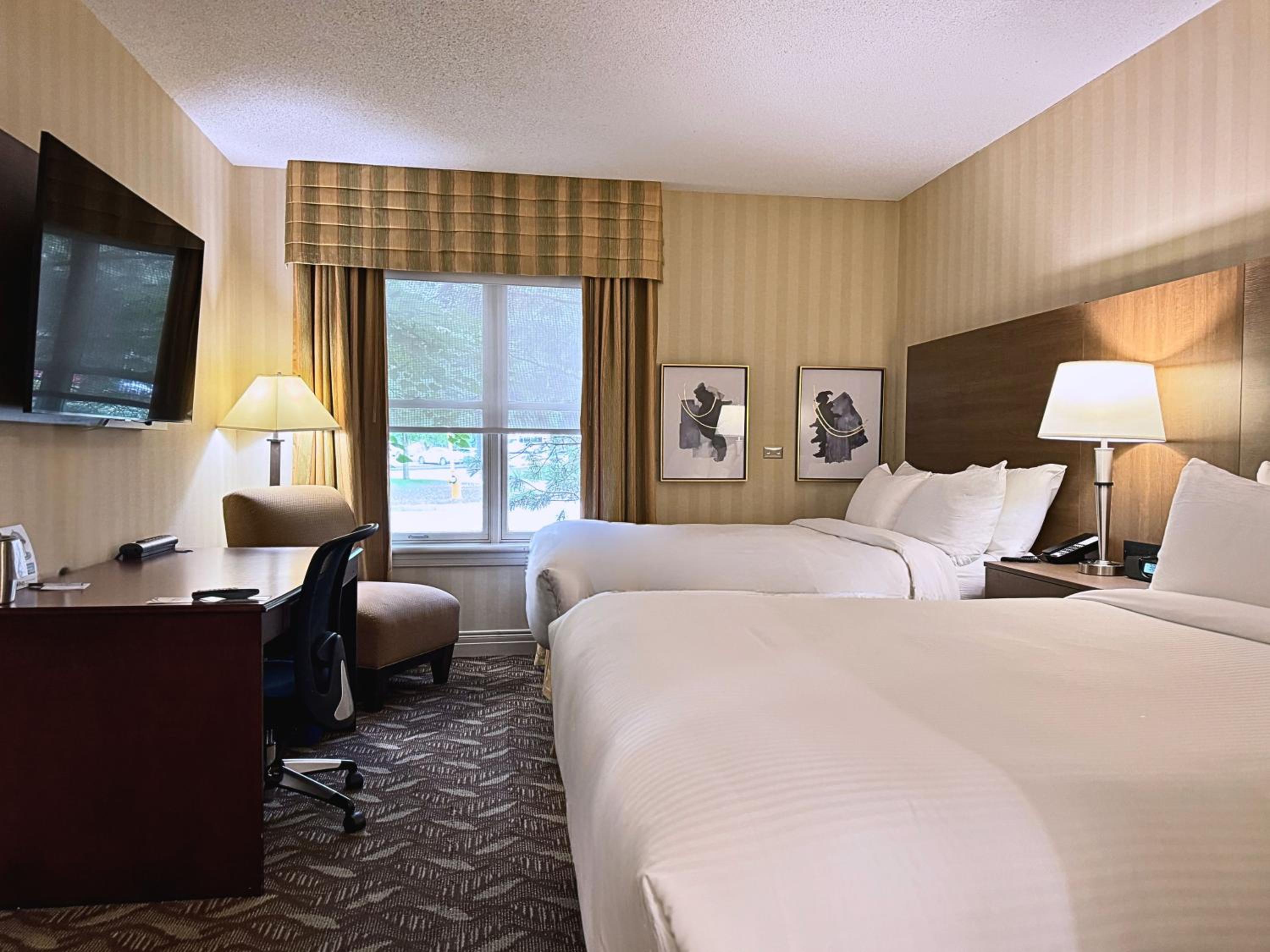 hotel room with two beds and a flat screen tv
