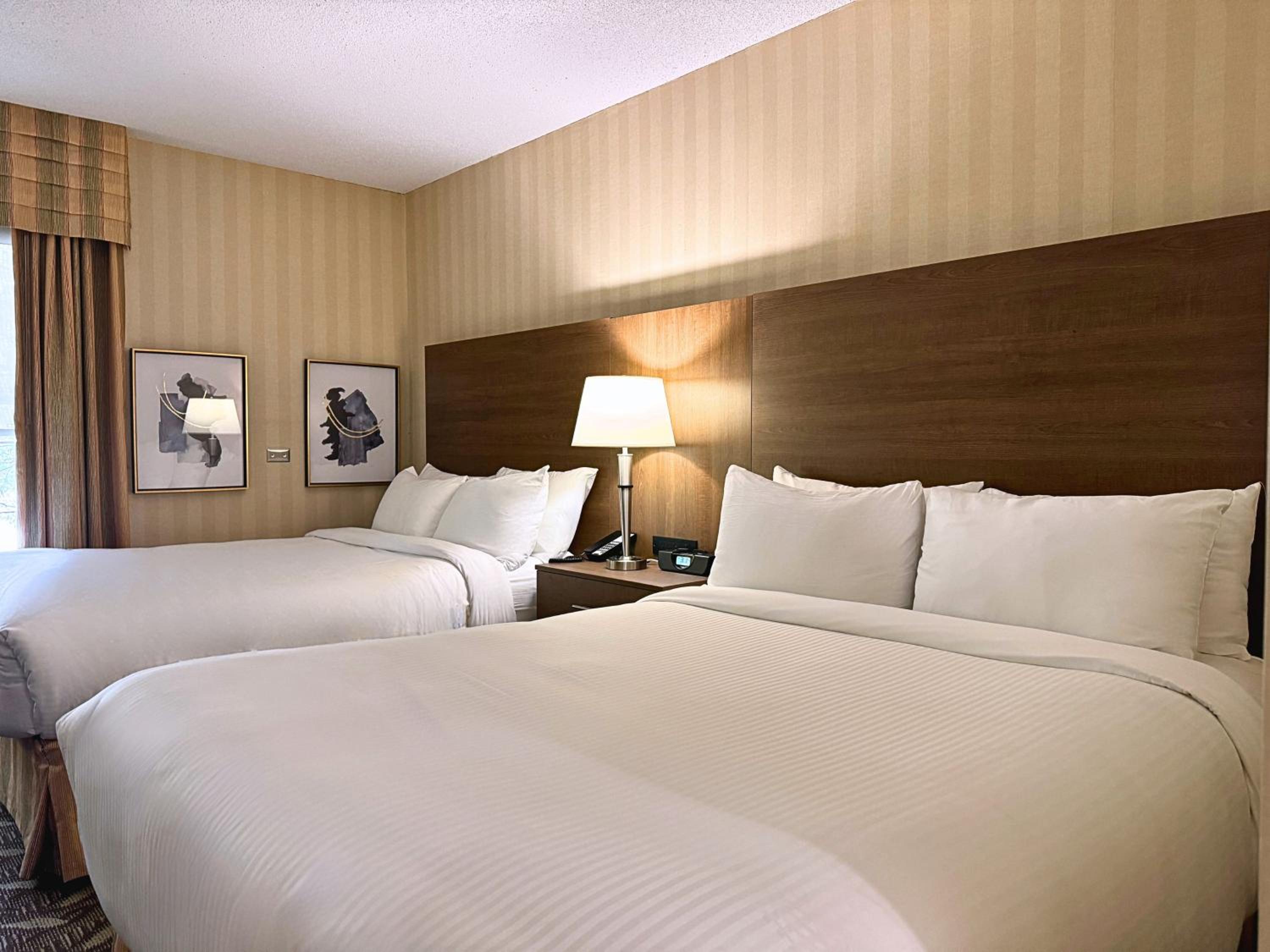 hotel room with two queen sized beds and a flat screen tv