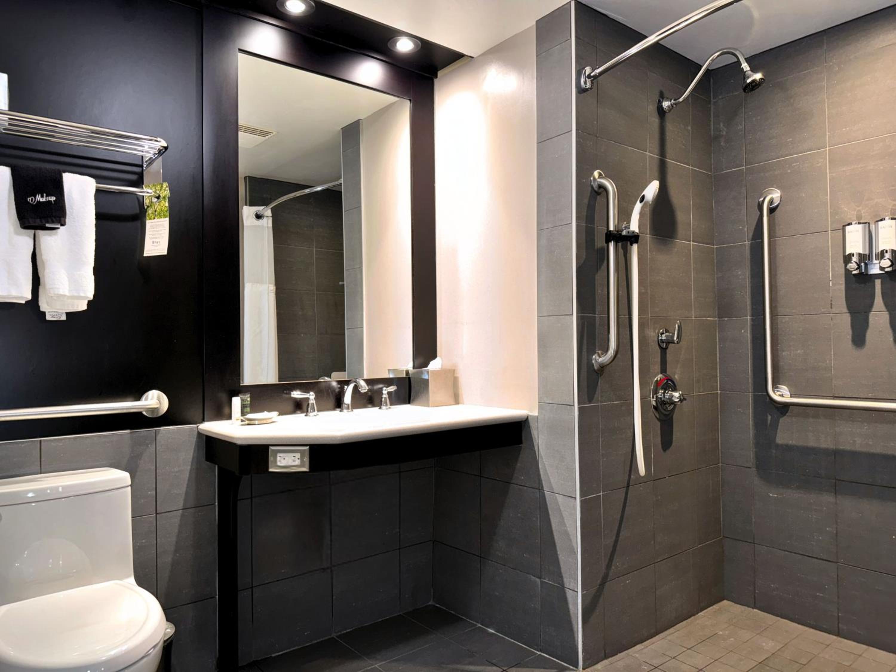 bathroom with a toilet, sink, and shower stall