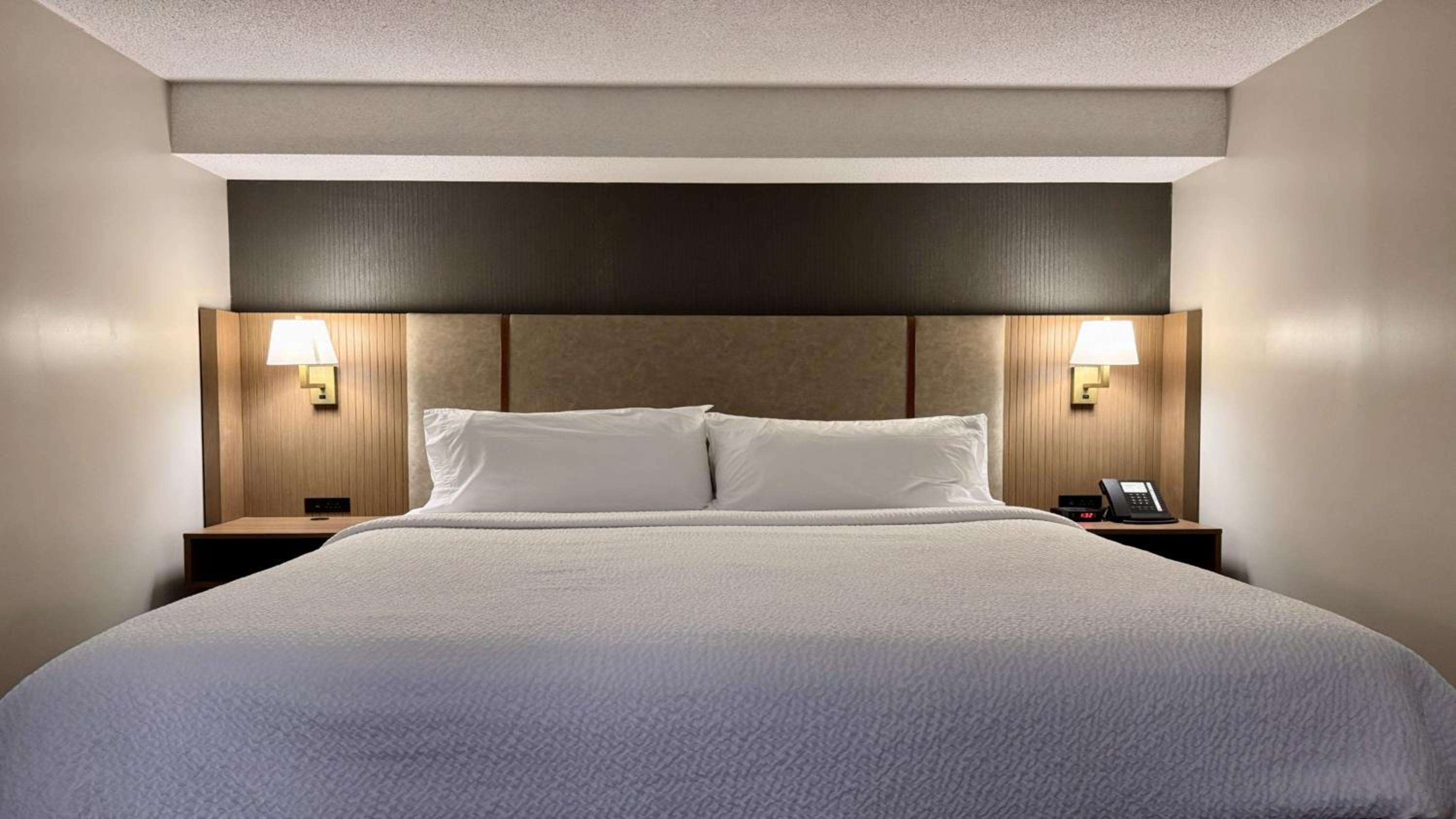 hotel room with a white bed and brown headboard