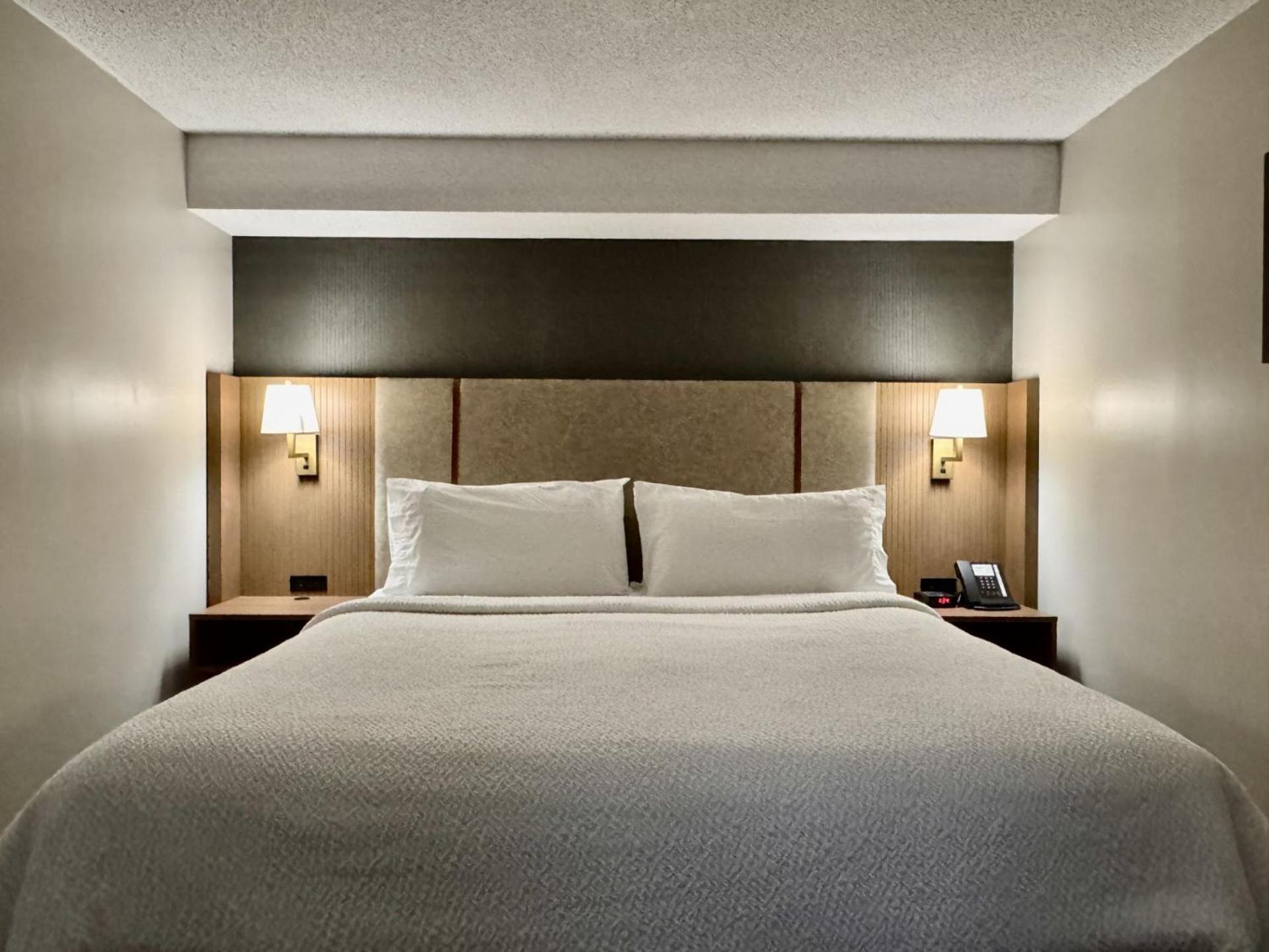 hotel room with a white bed and brown headboard