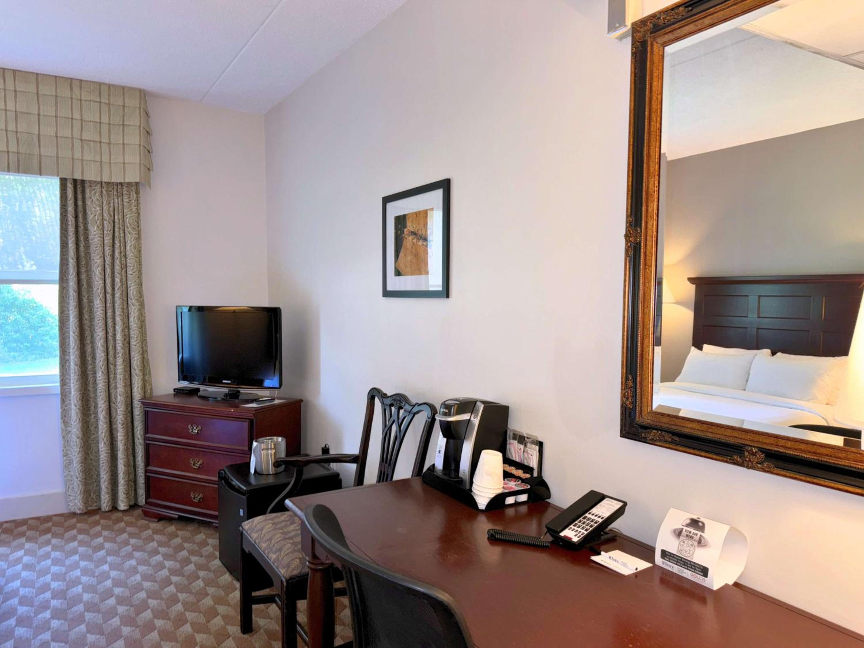 hotel room with a desk, chair, and television